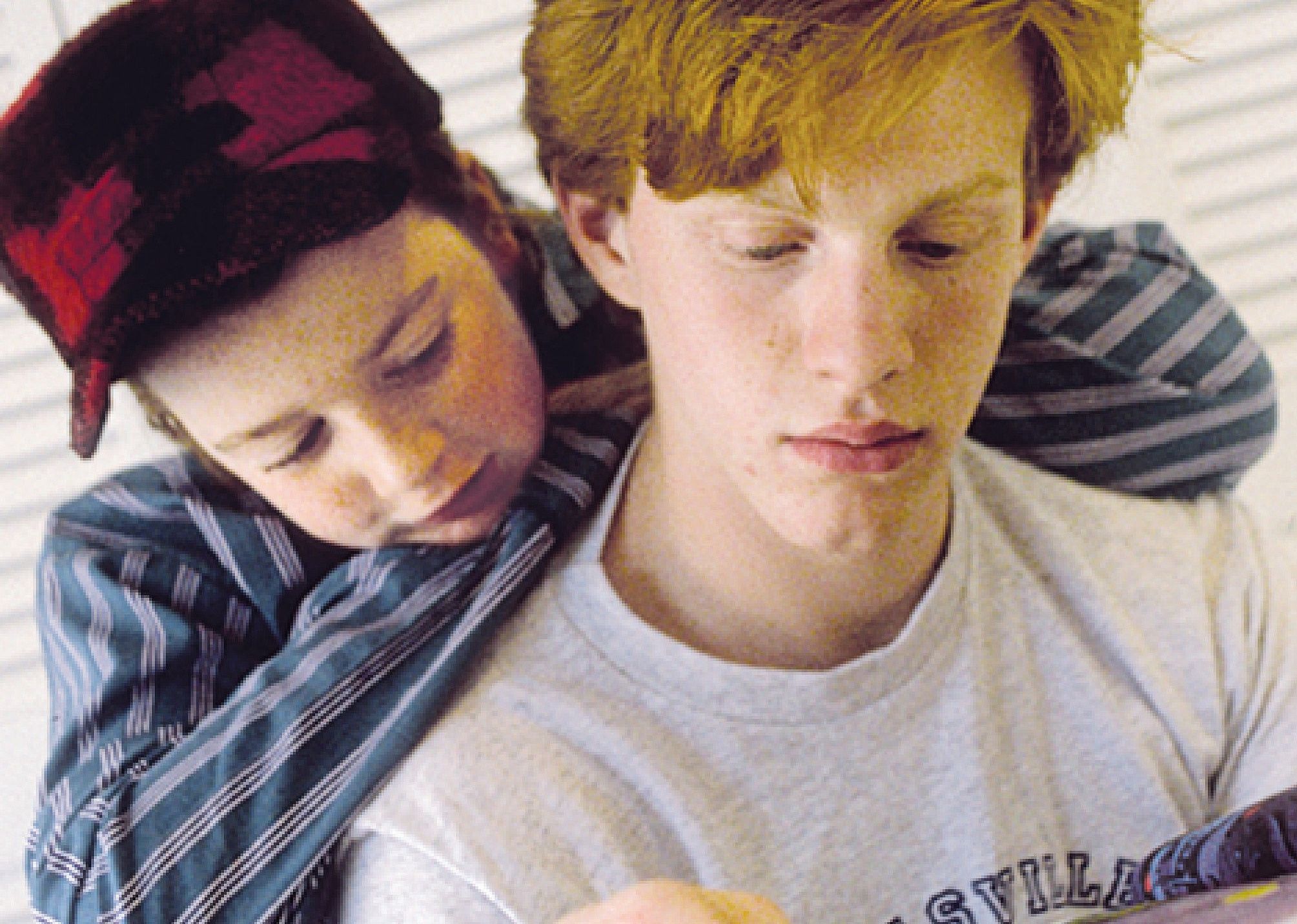 Two boys looking at a magazine.