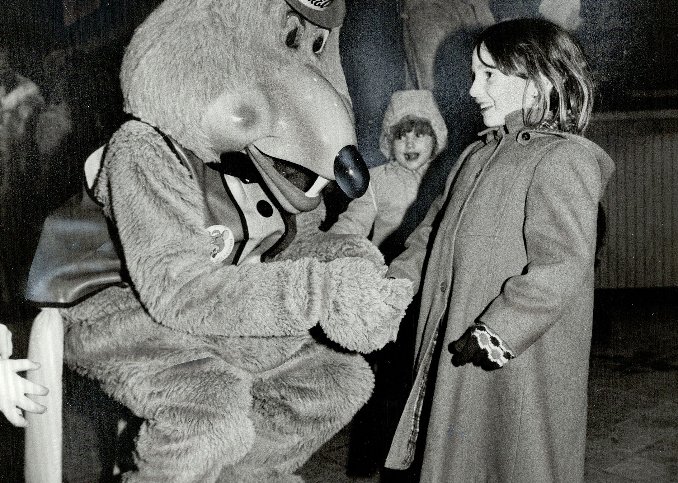 A young girl with a person dressed as Chuck E. Cheese in 1987.
