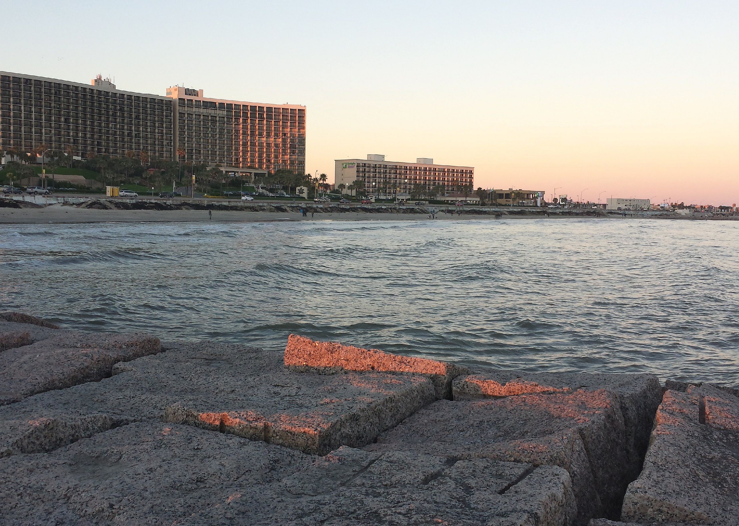 Sunset and buildings along water.