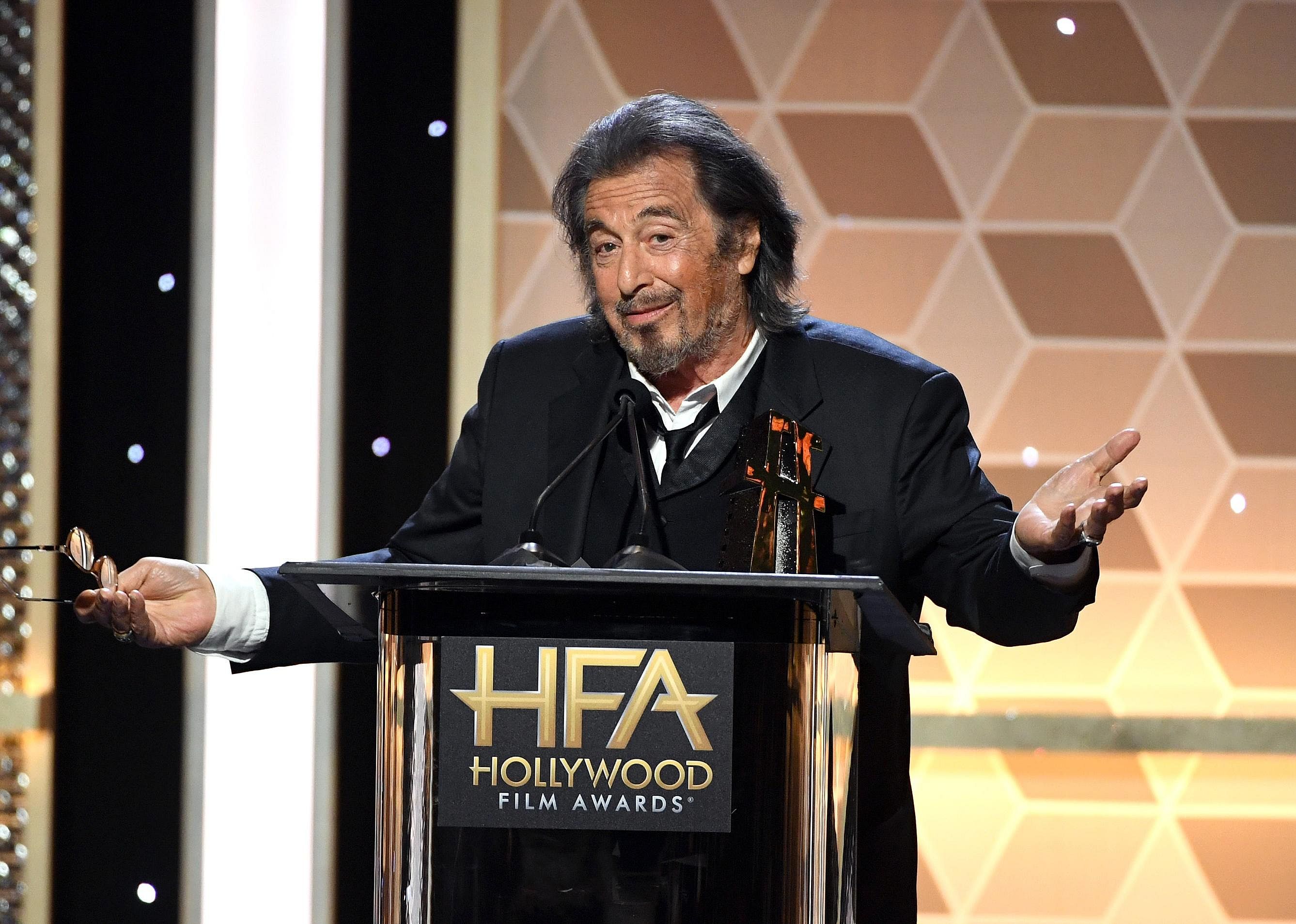 Al Pacino speaking behind a podium at the Hollywood Film Awards.