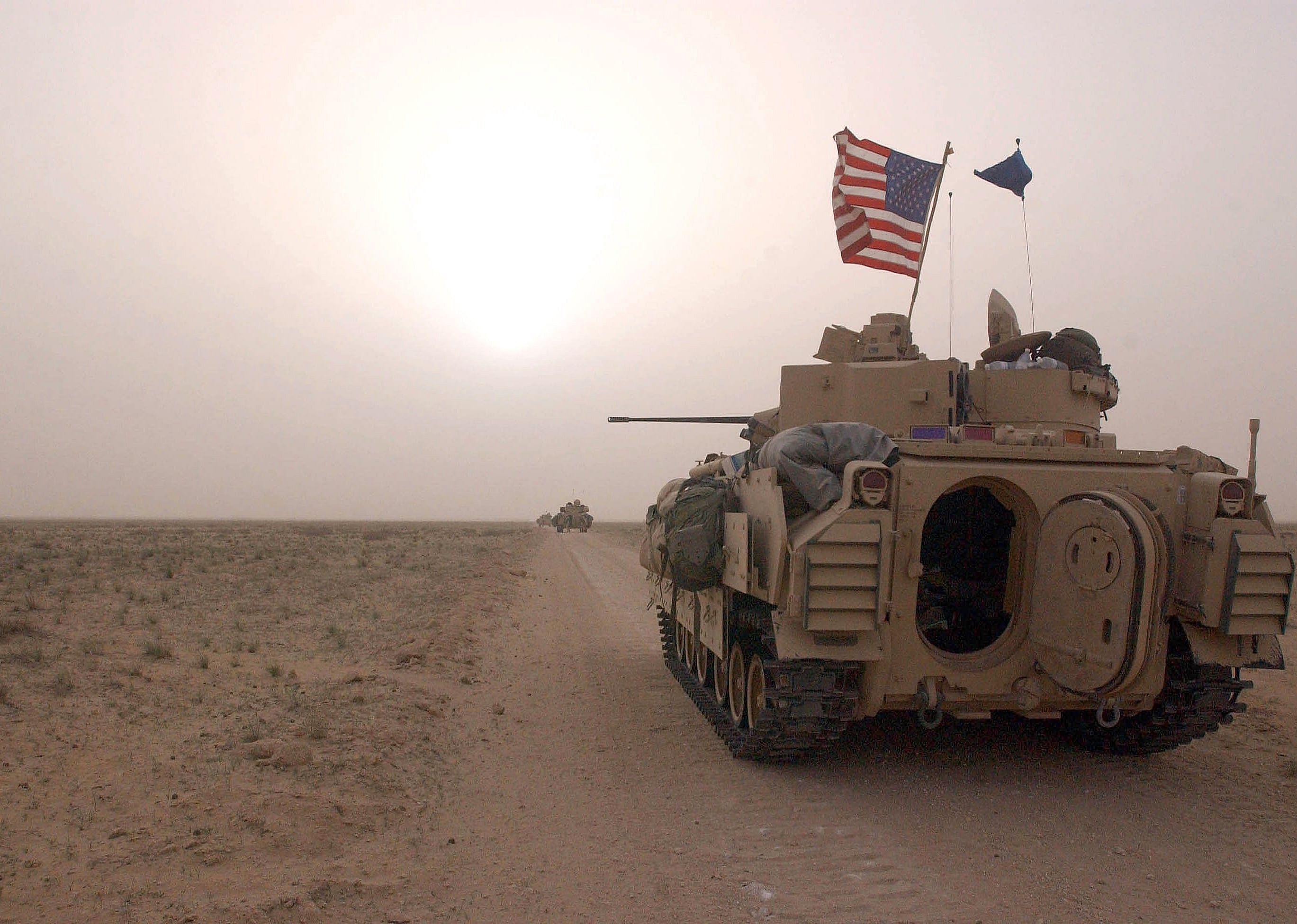 U.S. Army 3rd Division 3-7 Bradley fighting vehicles take up a position along a road.