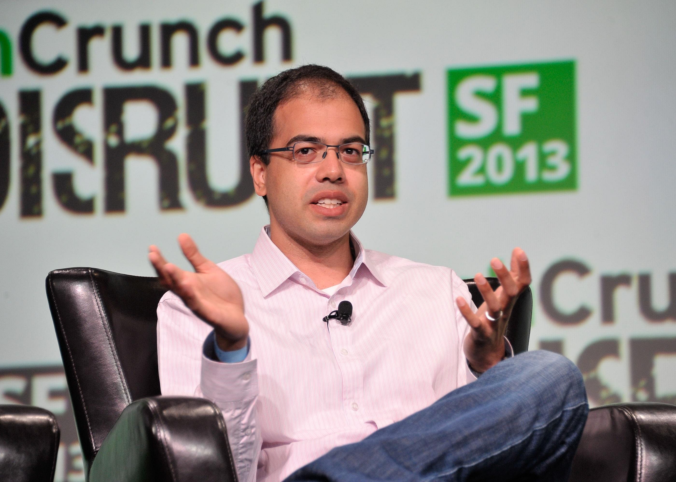 Sanjit Biswas sitting in a black leather chair on stage.
