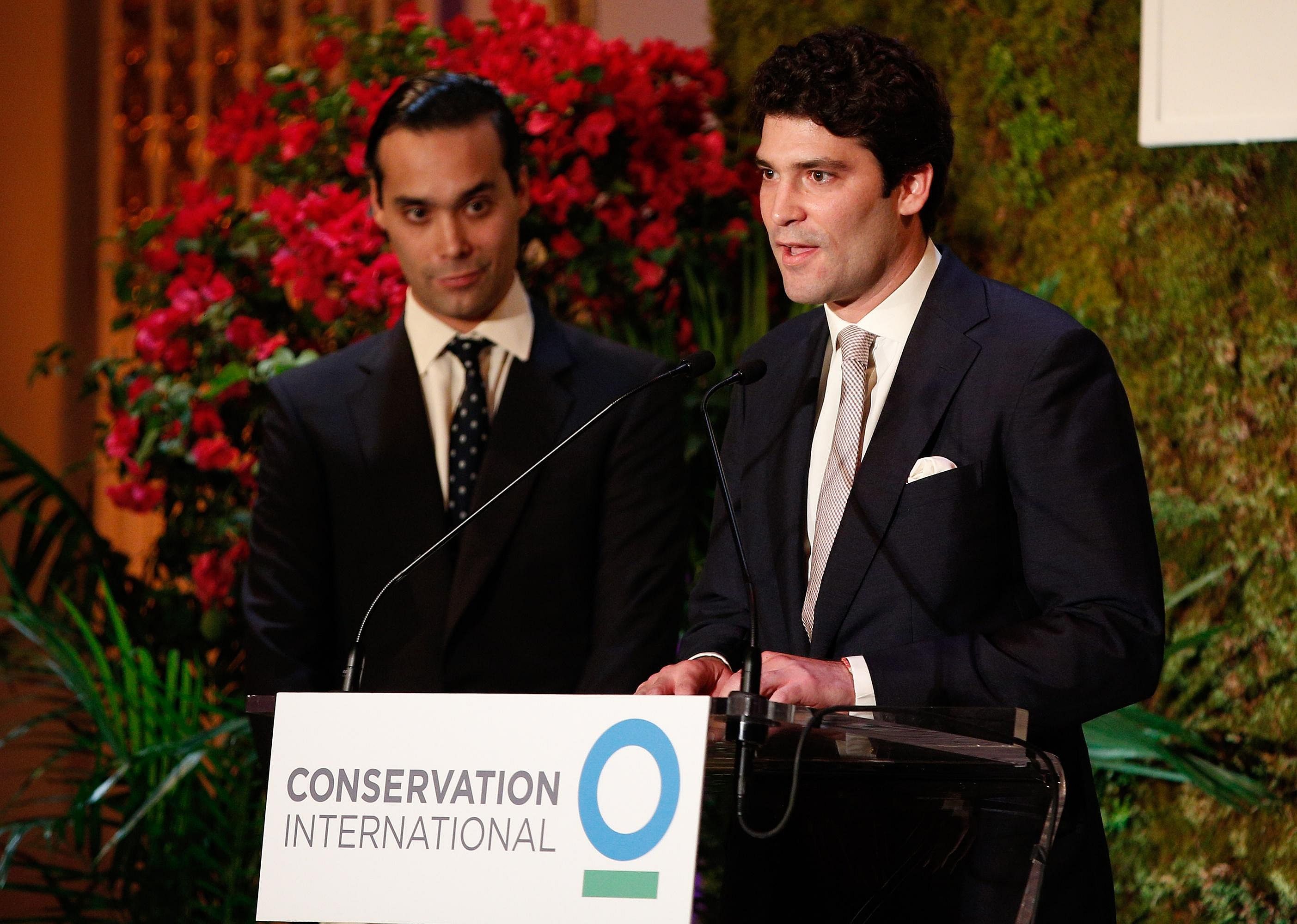 Alejandro Santo Domingo standing at a podium in a black suit.