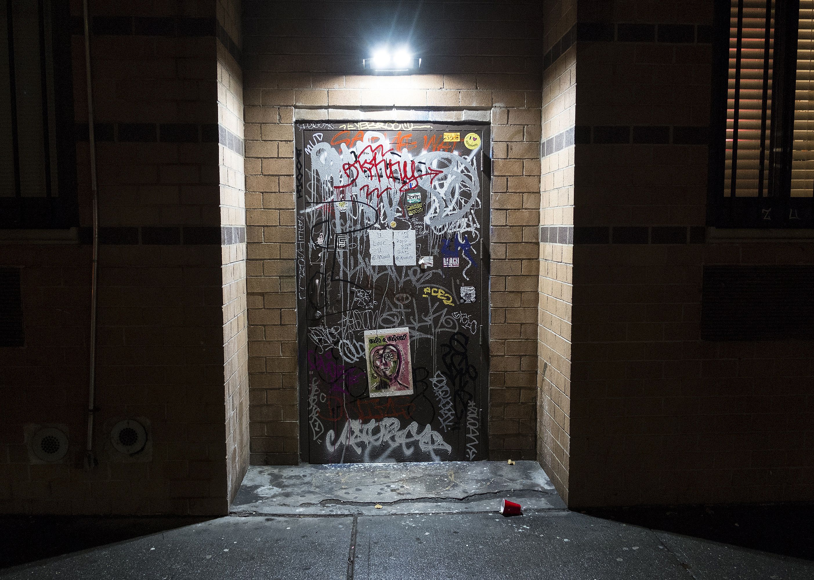 A doorway to a brick building covered in graffiti.