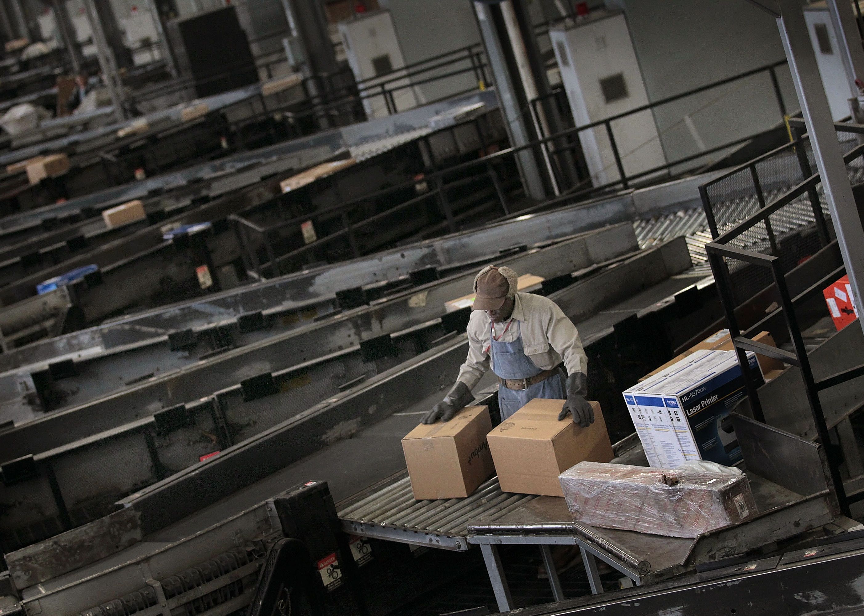 A worker sorts packages at a UPS facility.
