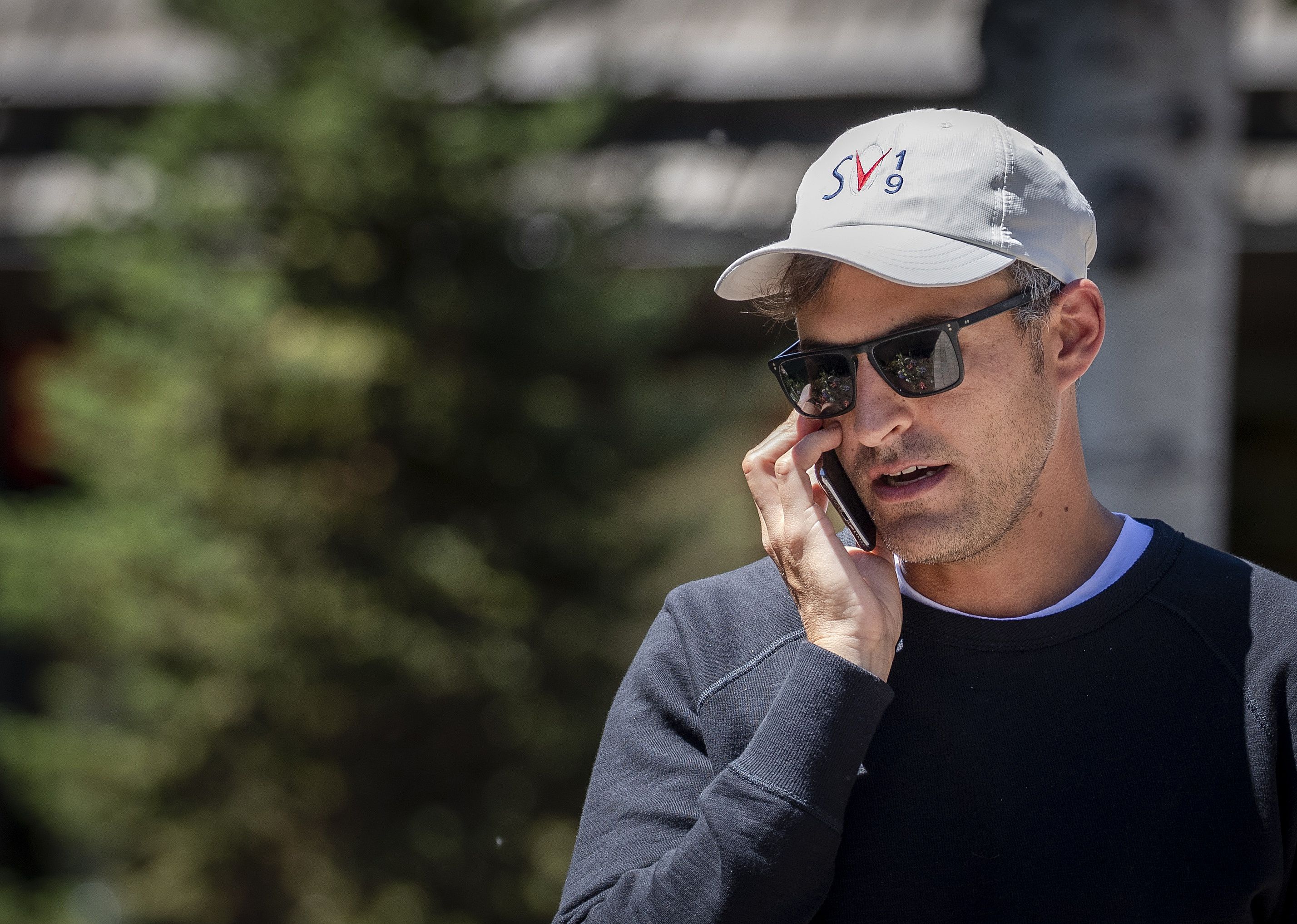 Paul Sciarra in a ball cap on the phone outside.