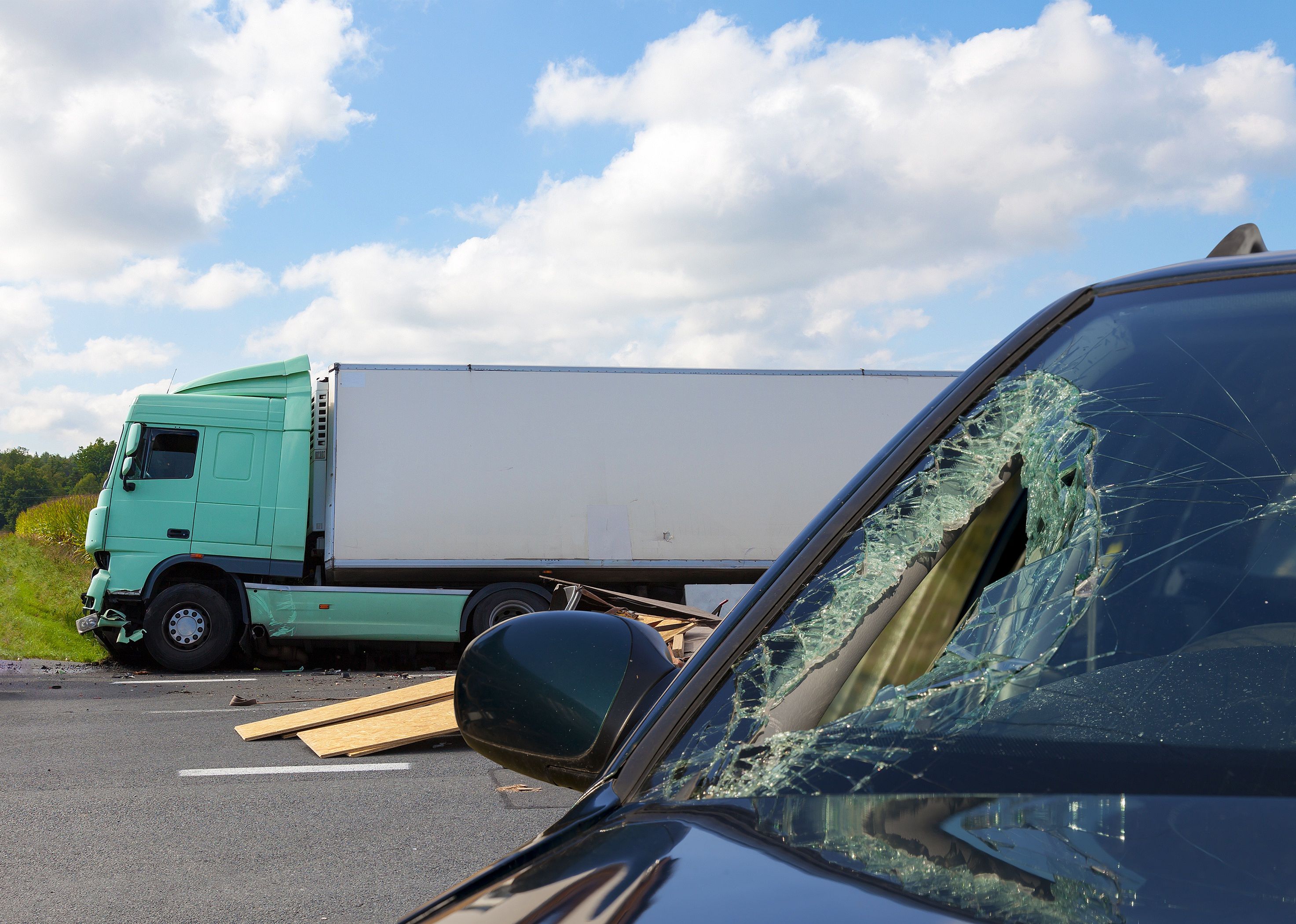 View of car after an accident with large truck in background