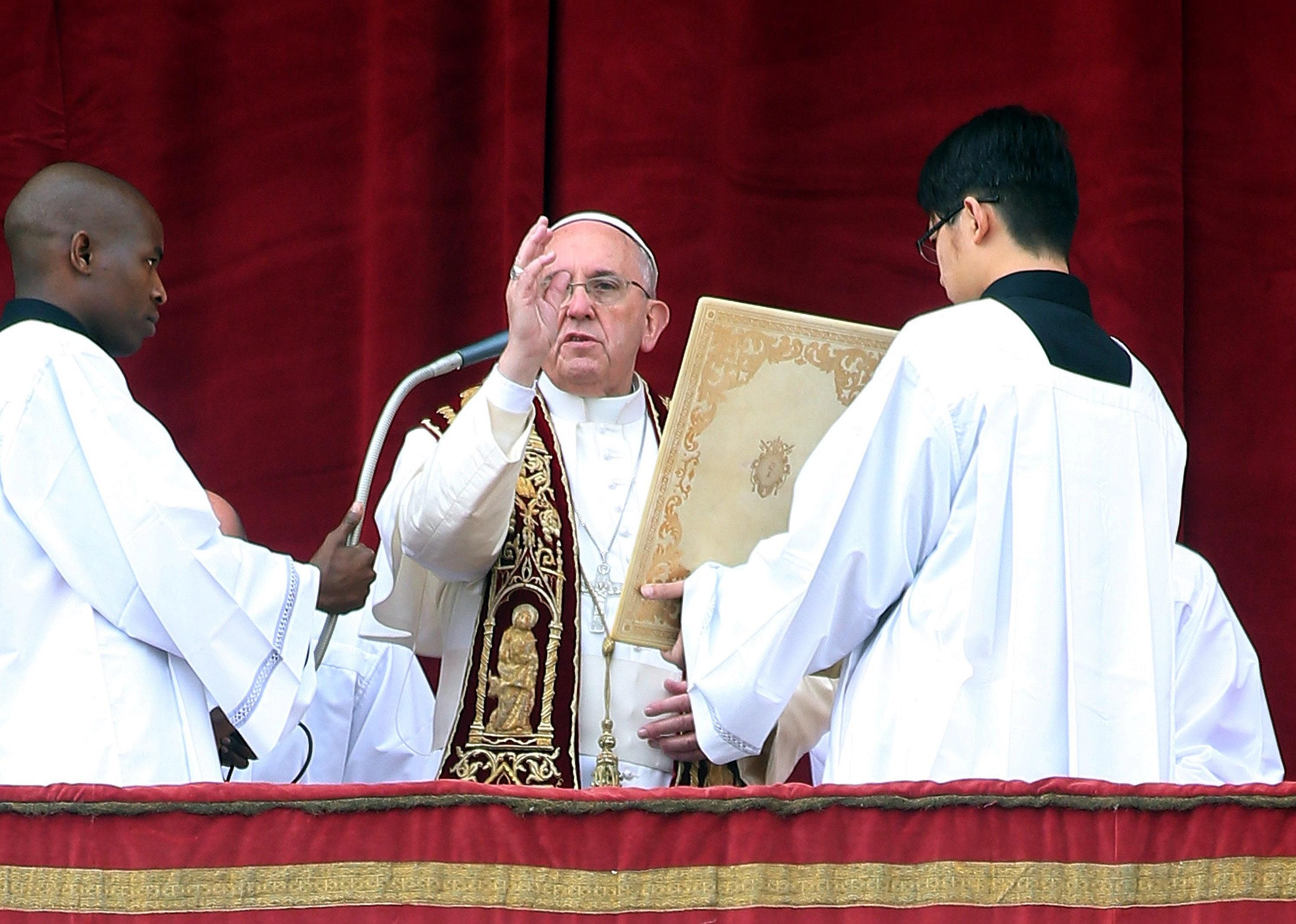 Pope Frances on the altar with attendants.