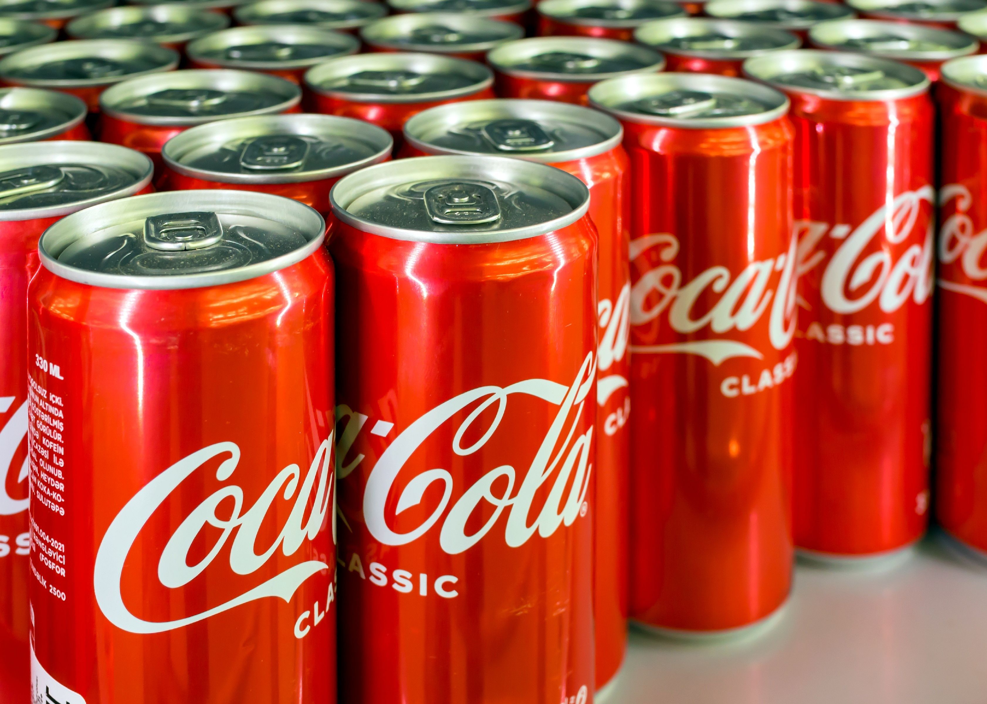 Several rows of Coca Cola cans.