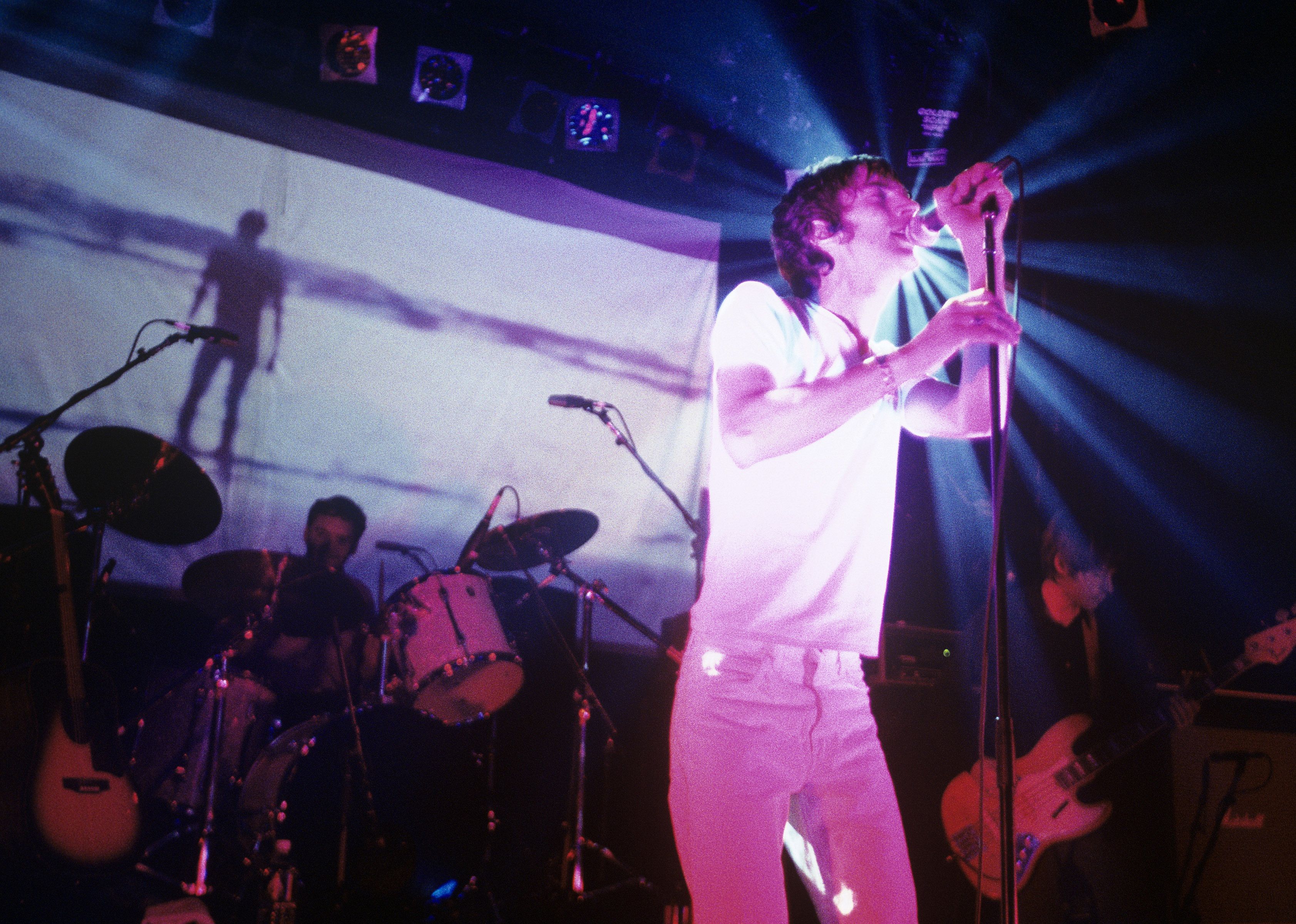  Richard Ashcroft of The Verve, with Peter Salisbury and Simon Jones behind, performing.