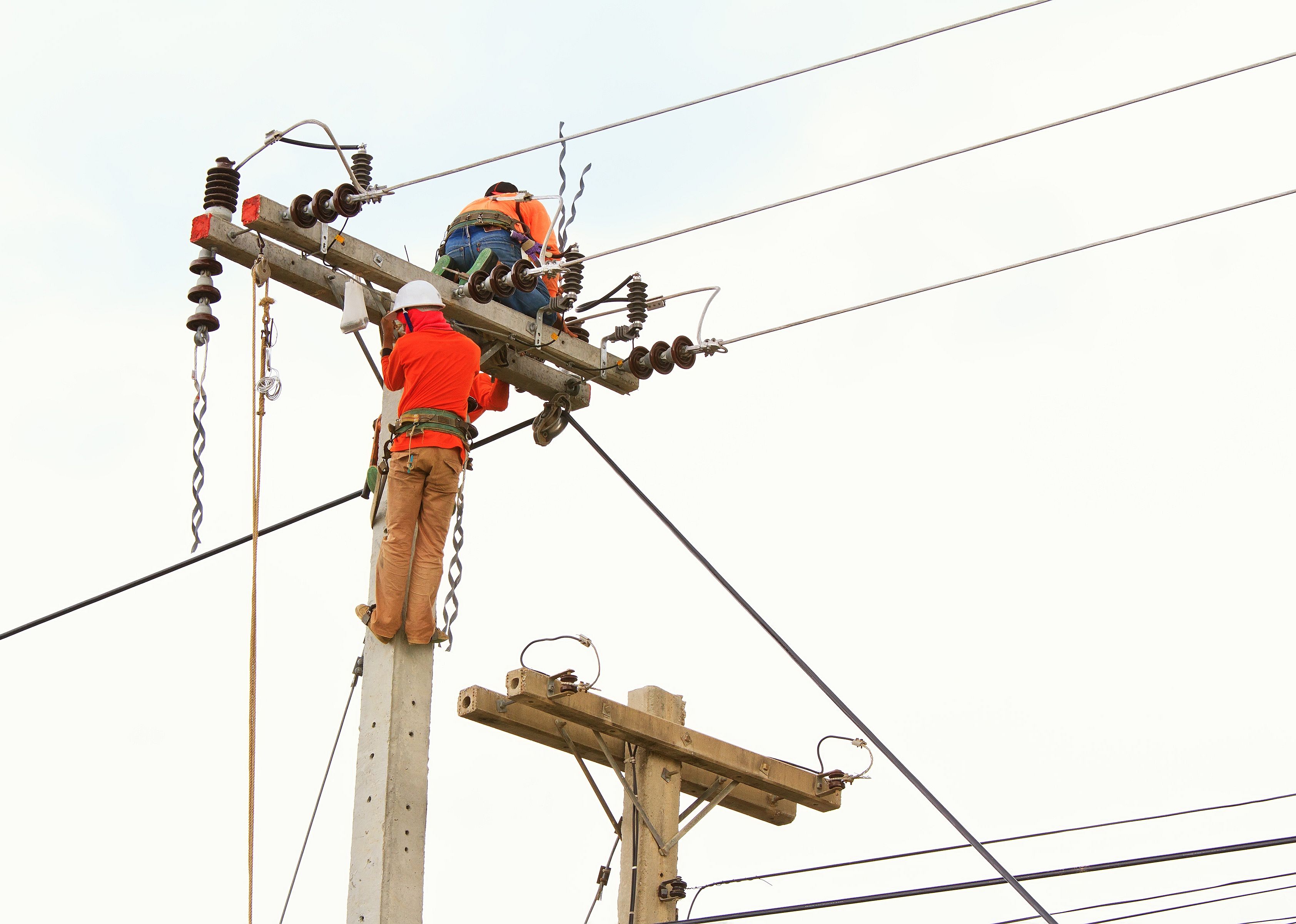 An electrical power utility worker in a bucket fixes the power line.