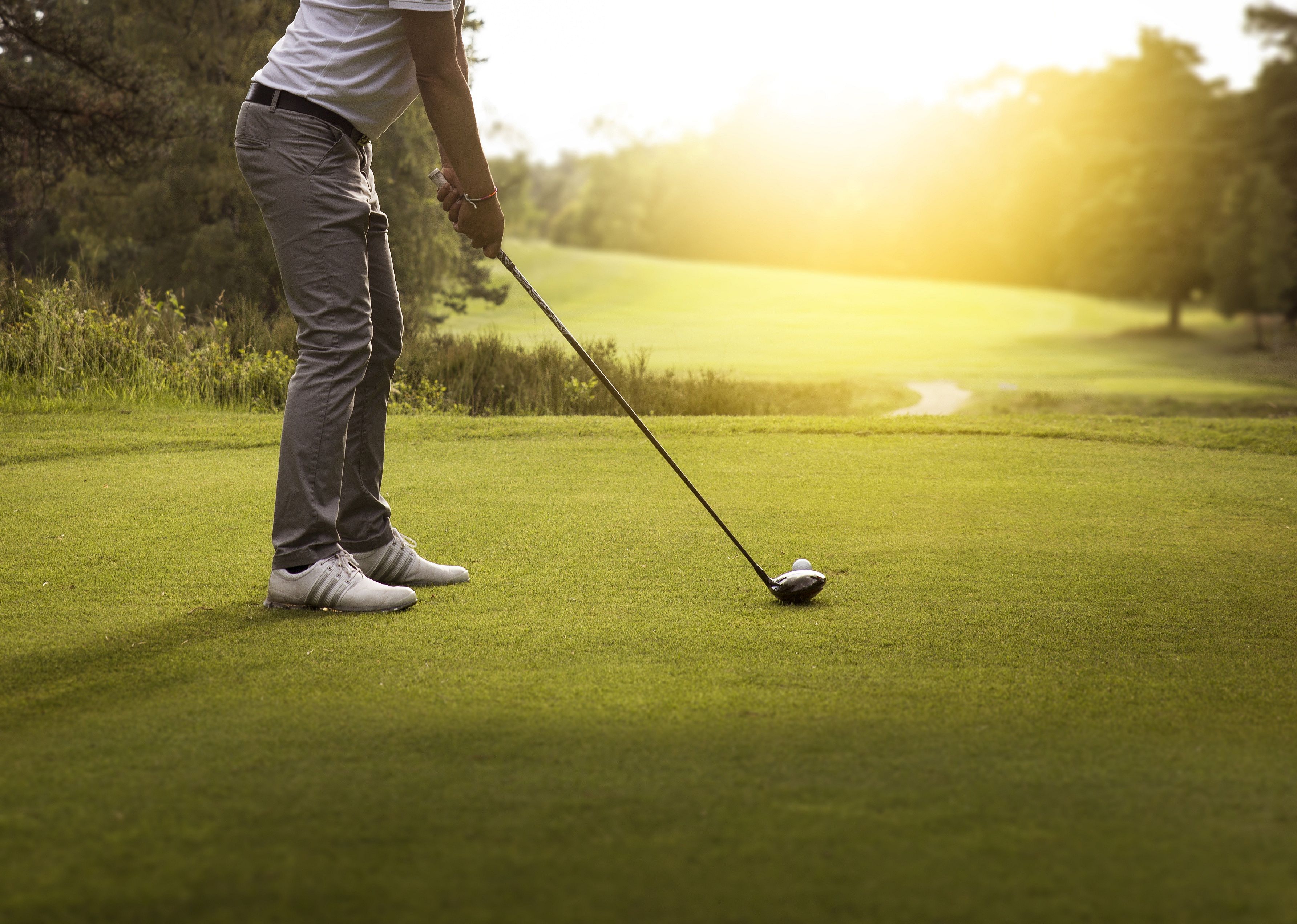 Person playing golf with sun streaming in.