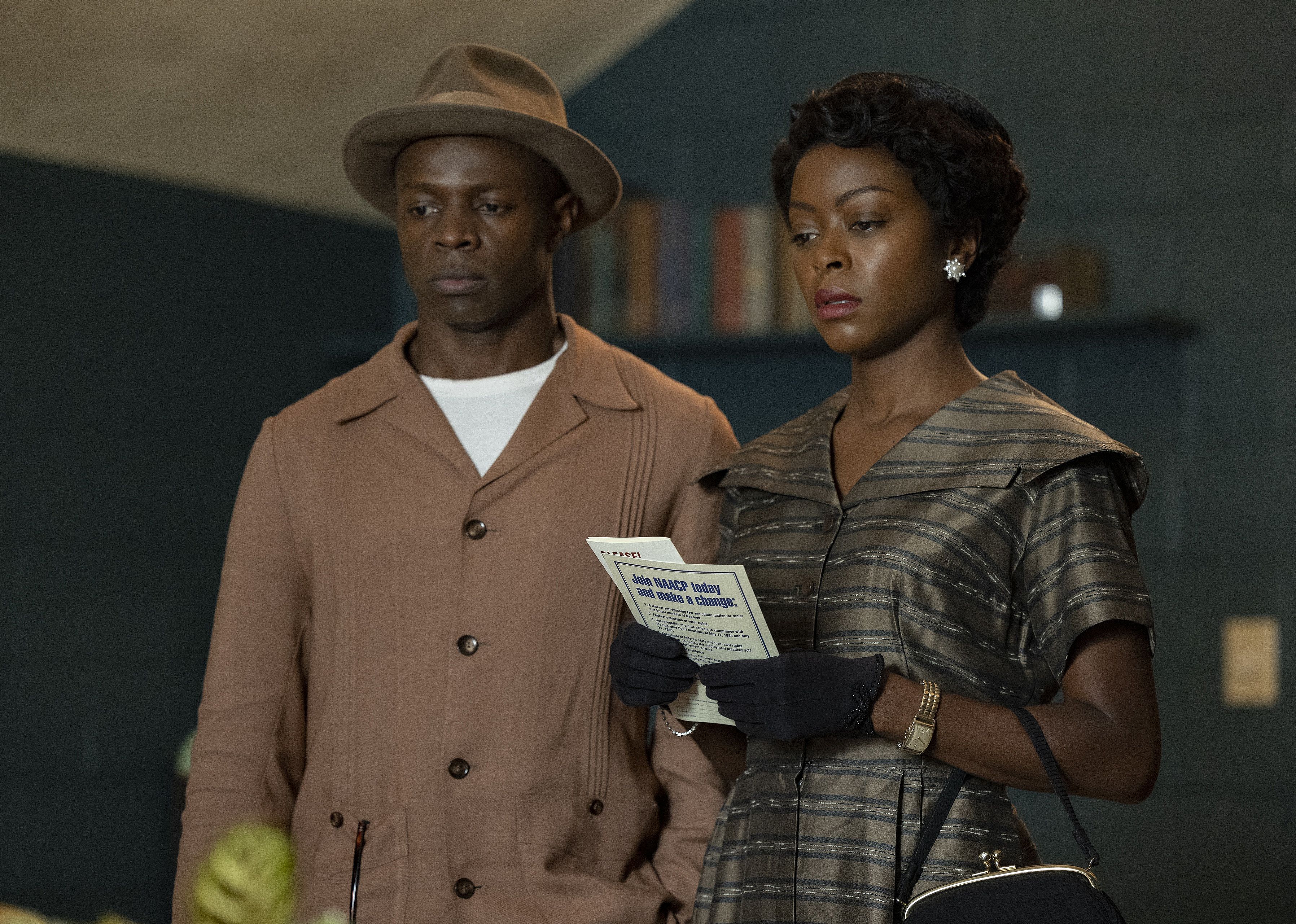 A black man standing with a black woman holding a NAACP pamphlet.