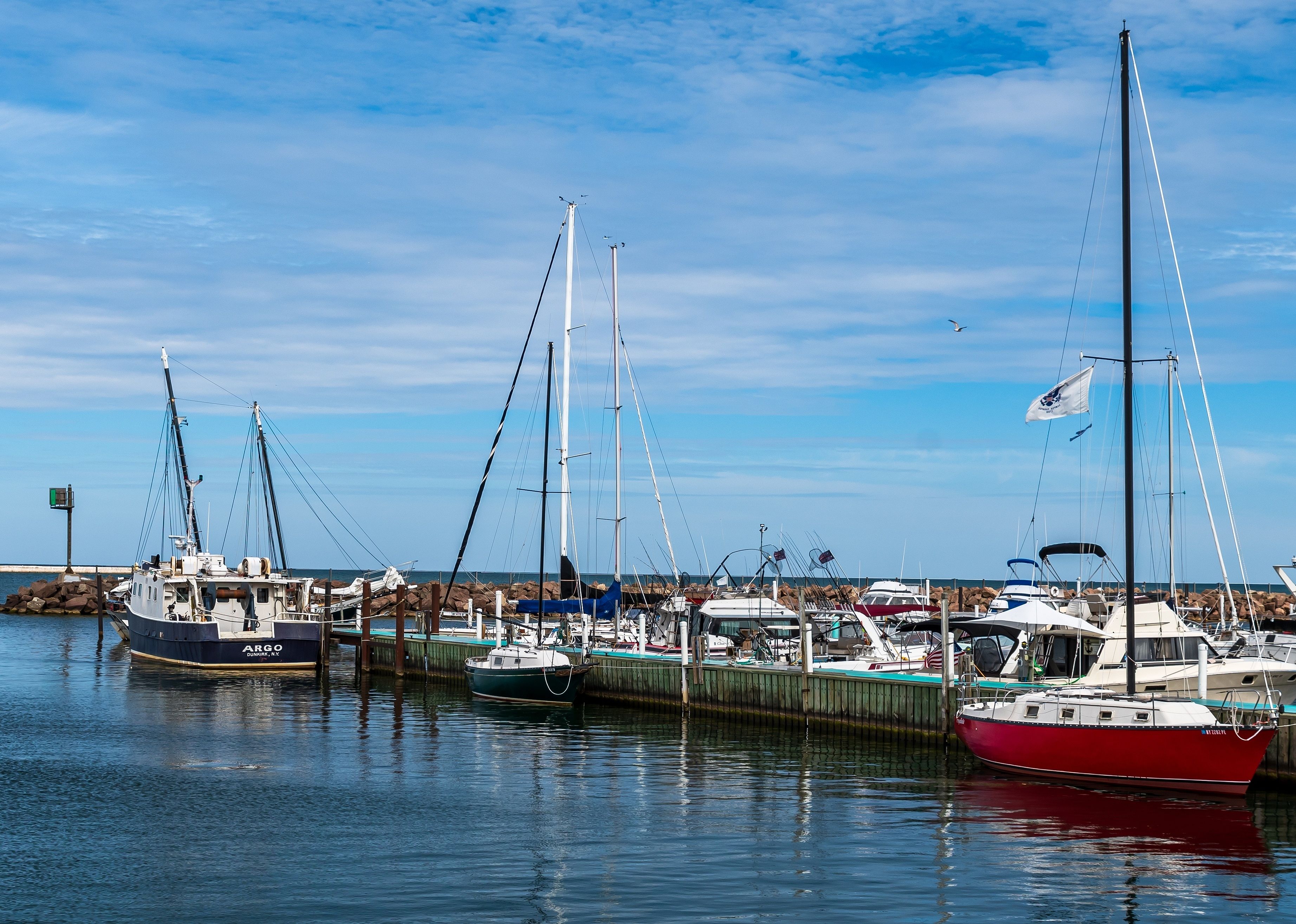 Boats docked at a marina next to the Dunkirk City Pier.