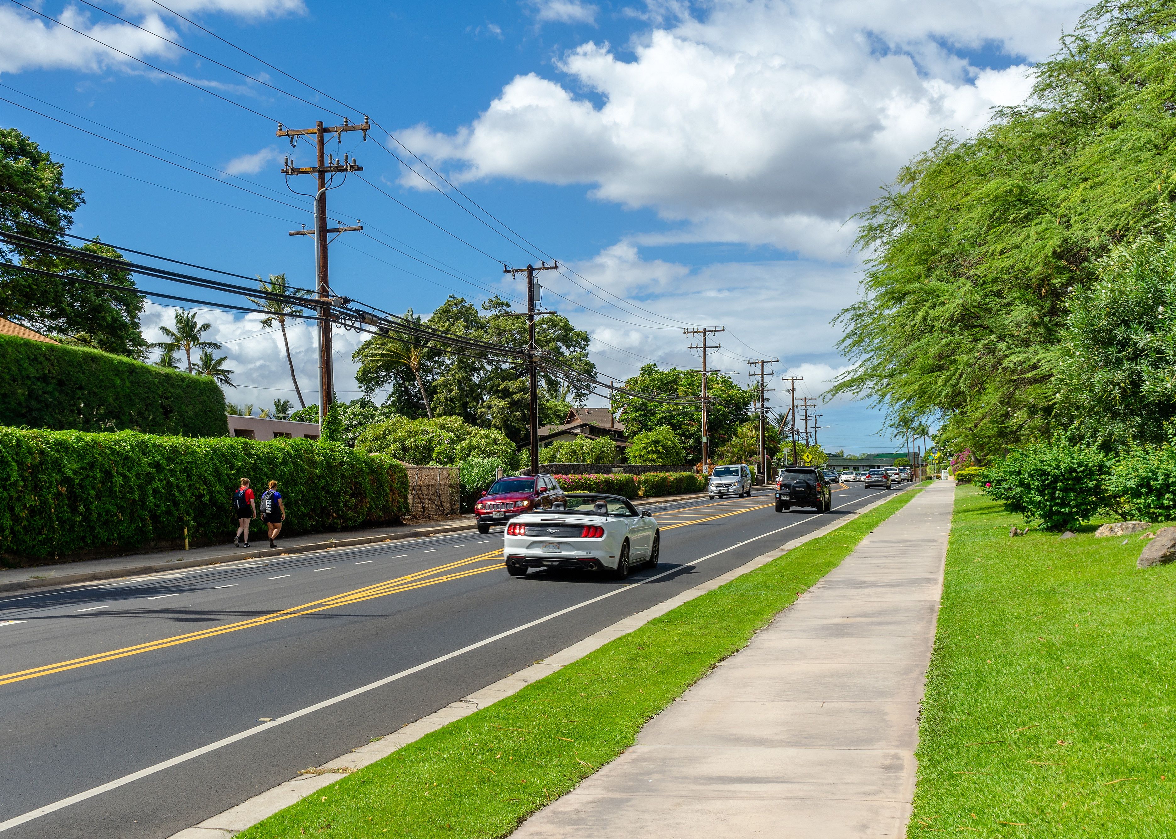 Roadway with cars and people walking.