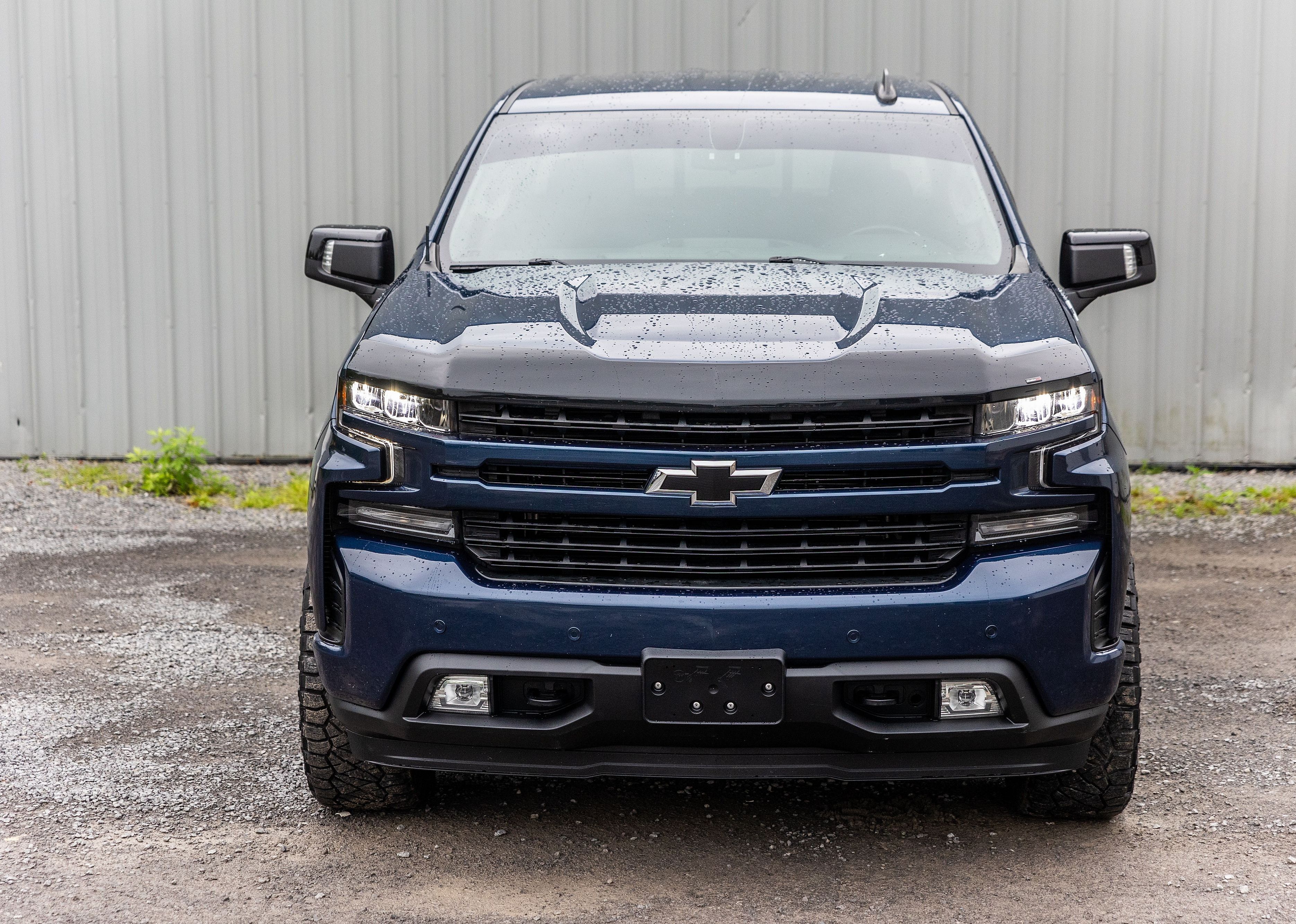 A blue Chevrolet Silverado pickup truck parked in a grassy field.