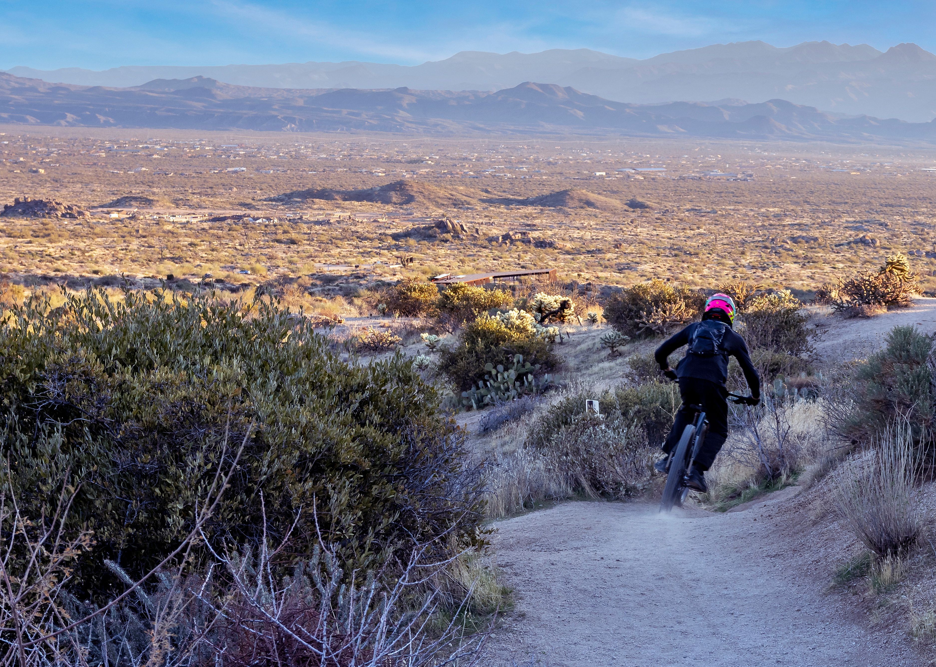 A guy riding a mountain bike down Toms Thumb Trail in Scottsdale.