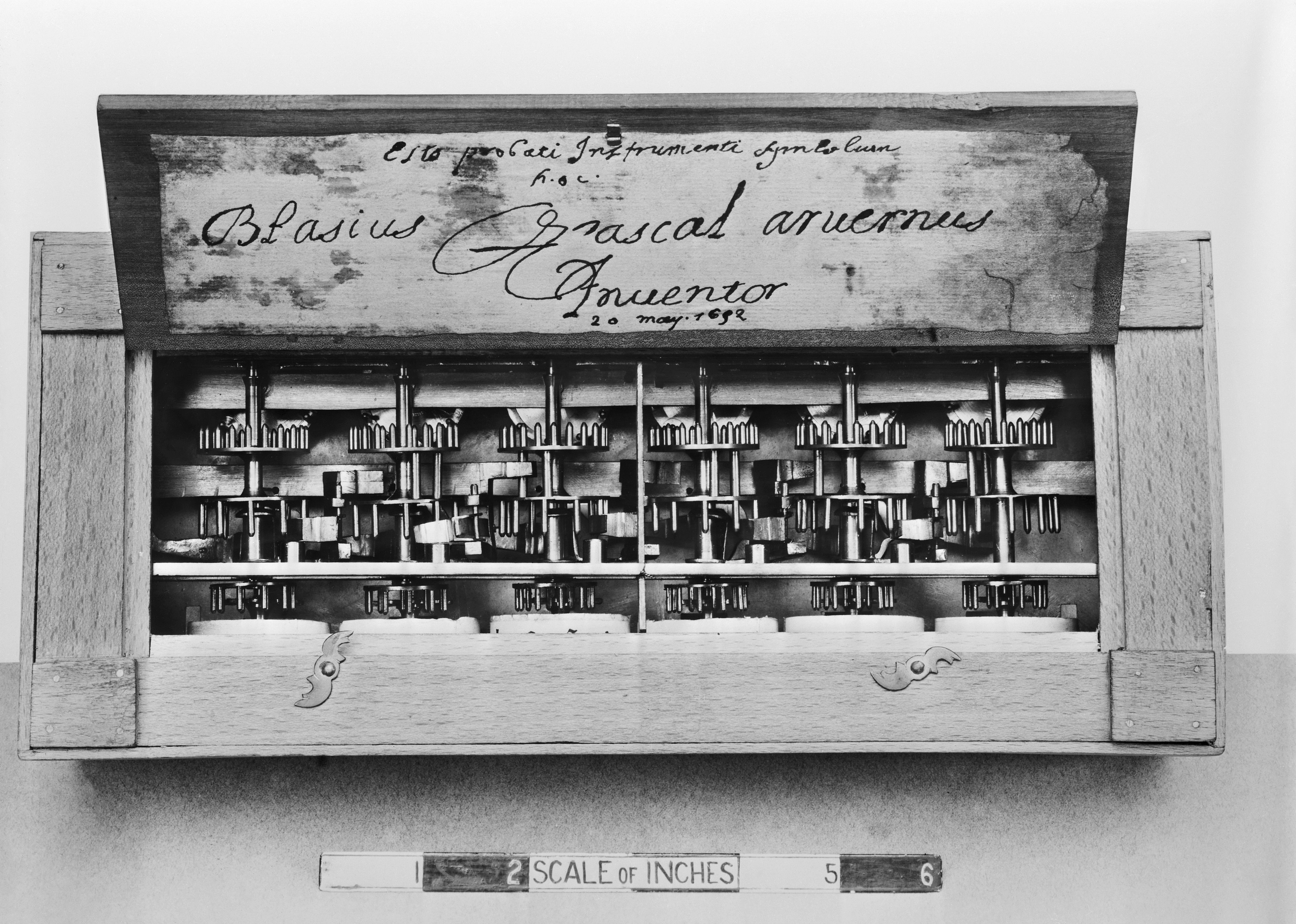 A replica of Pascal's rectangular adding machine with inscription of his name on the lid.