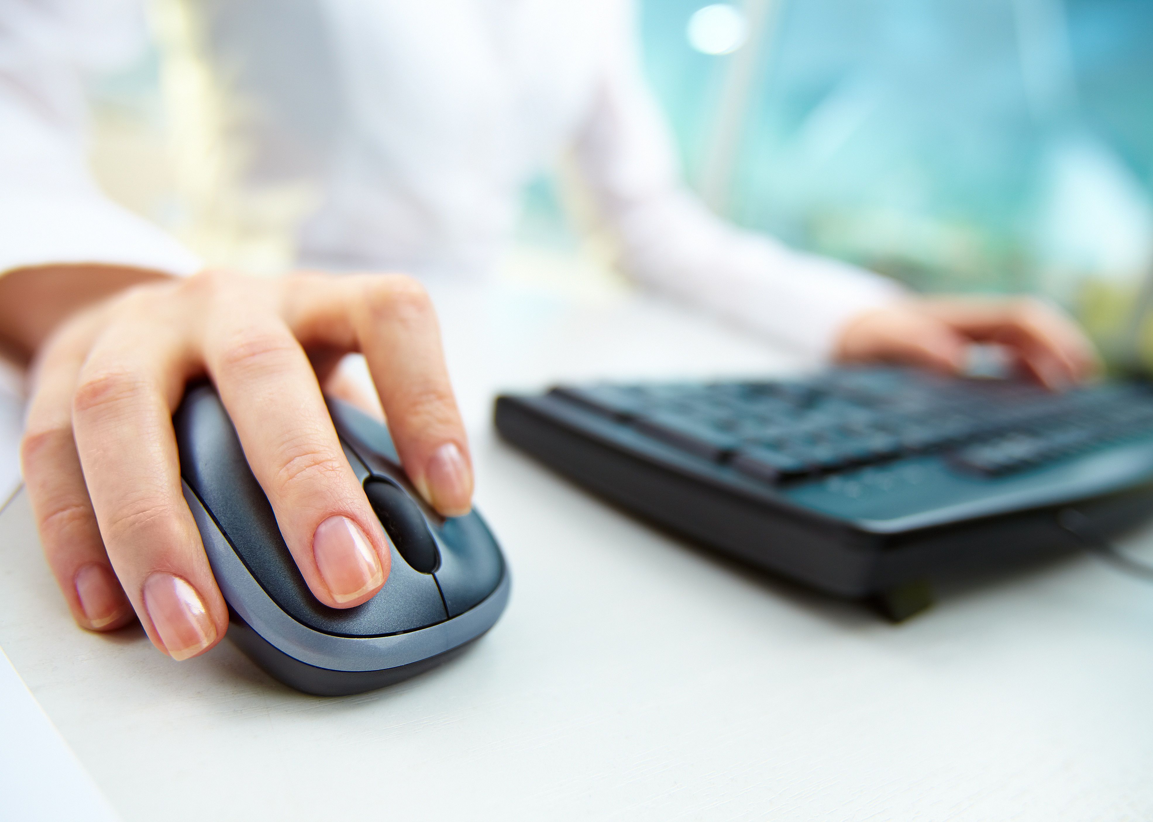 Image of female hands clicking computer mouse