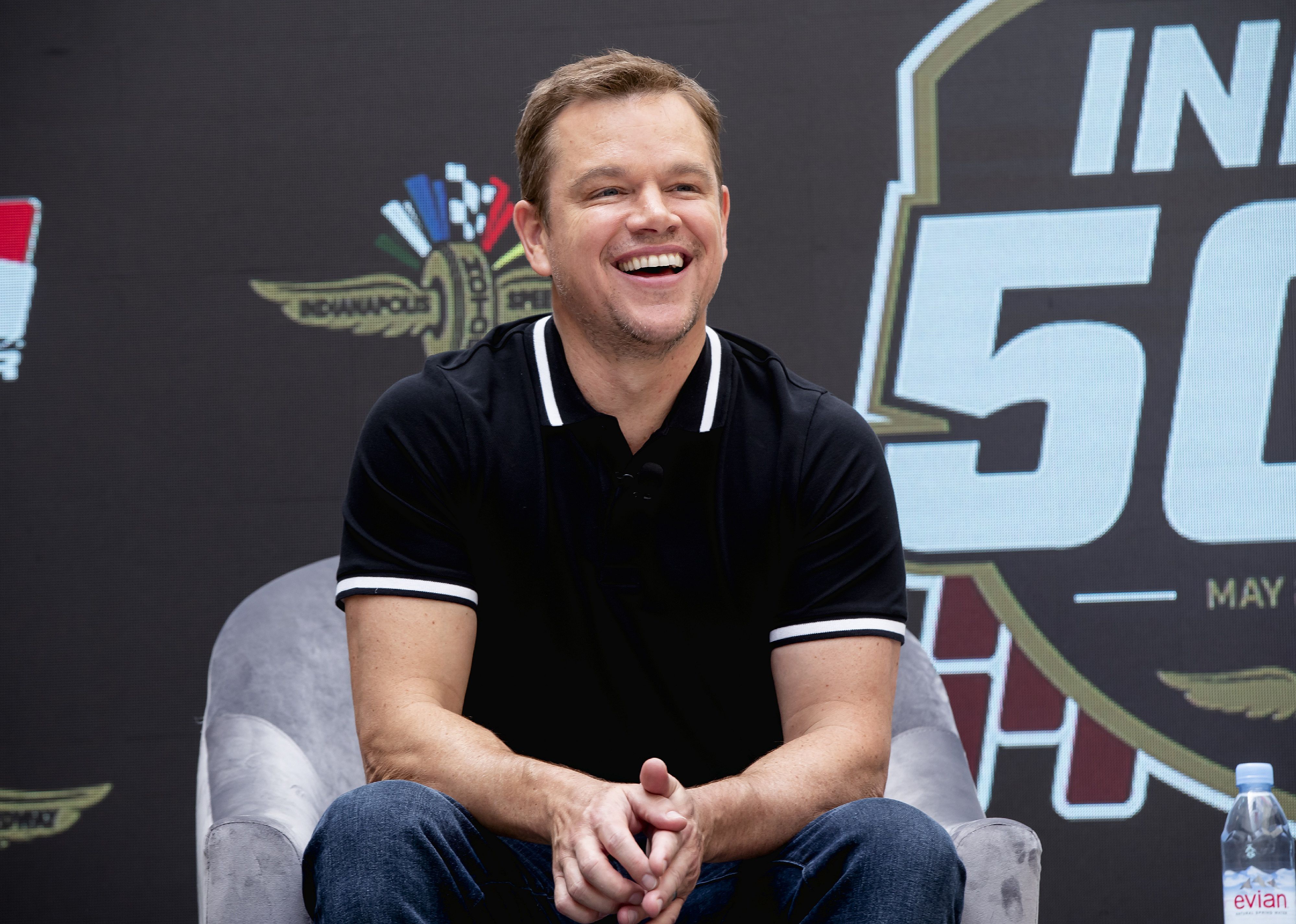 Matt Damon in a black polo shirt onstage.