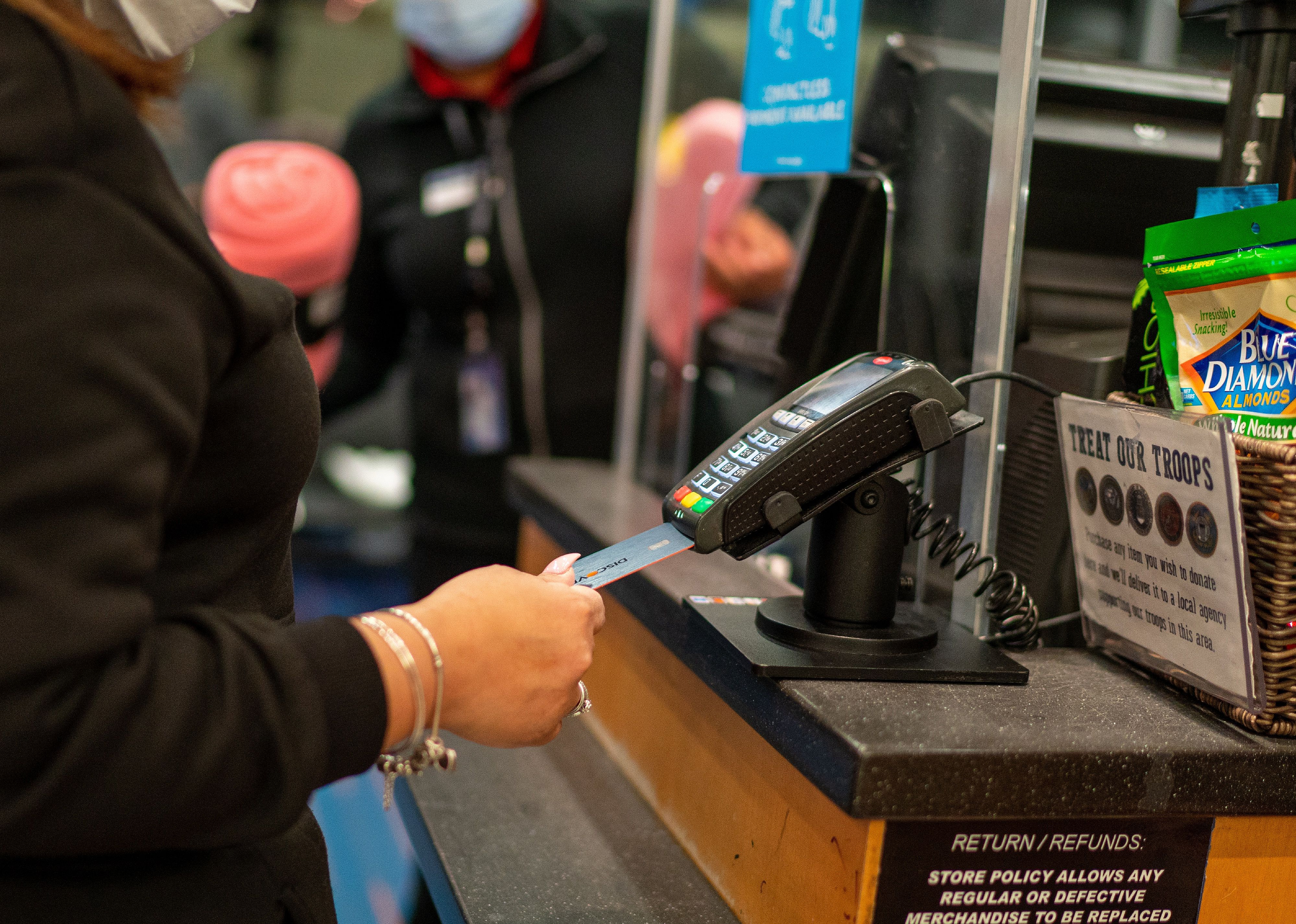 A person checking out at a desk with a credit card.