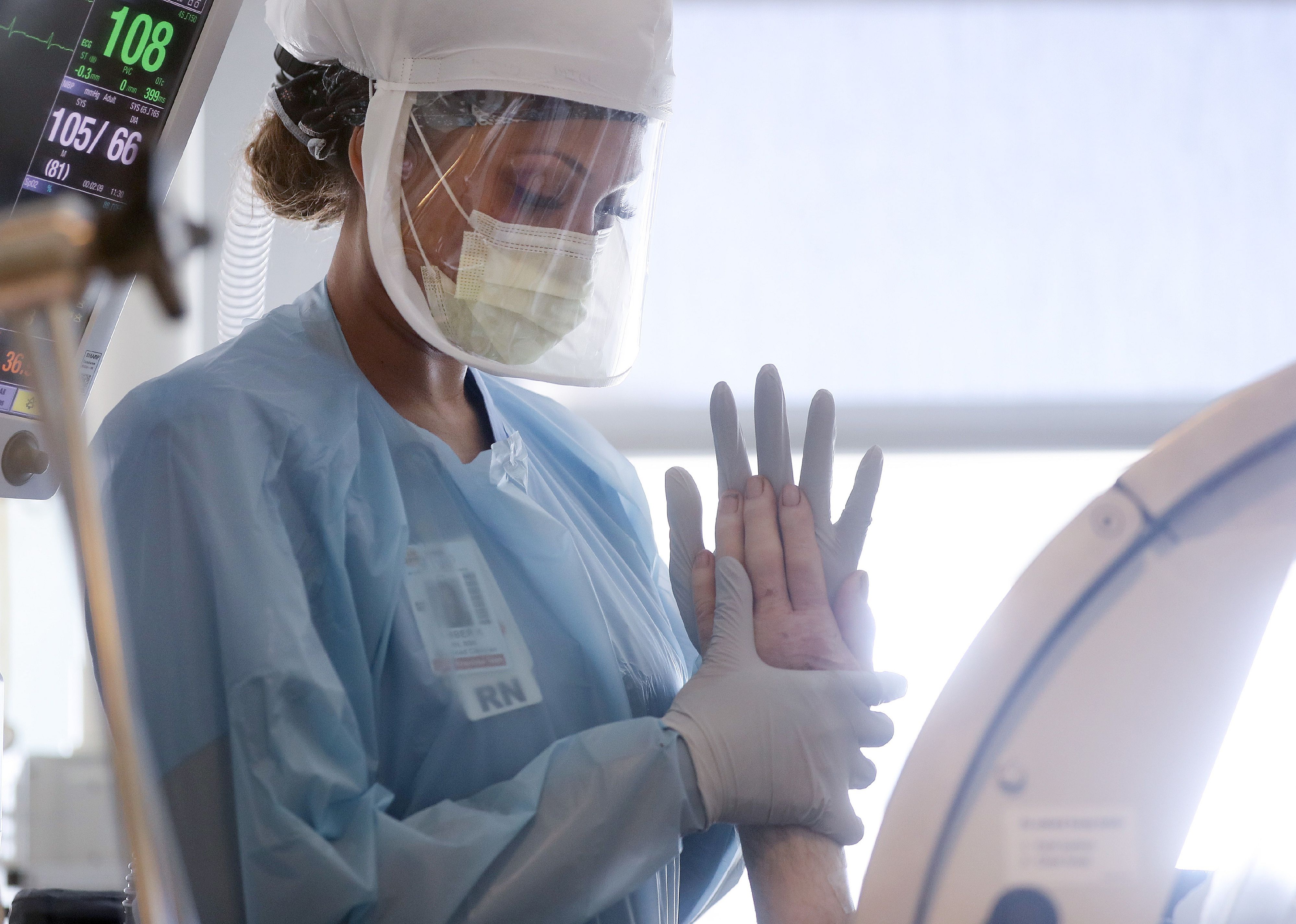 A nurse holds the hand of a patient.