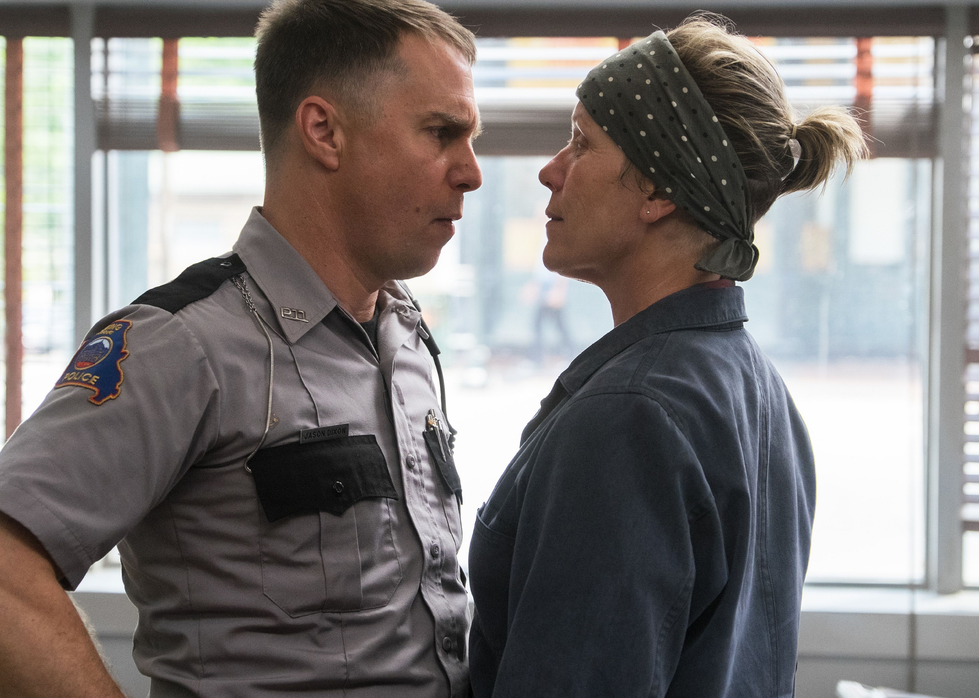 A woman in a gray jumpsuit gets in the face of a policeman.