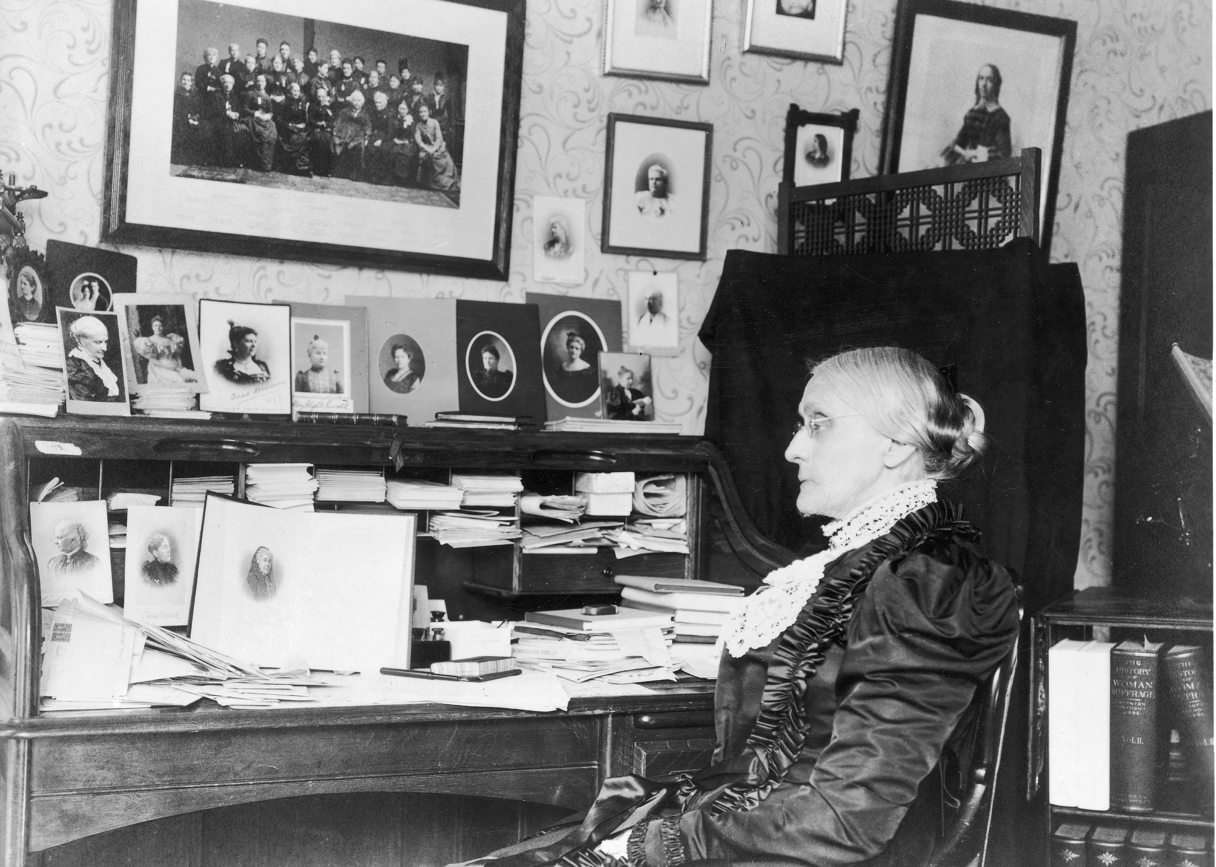Susan B. Anthony sitting at a desk.