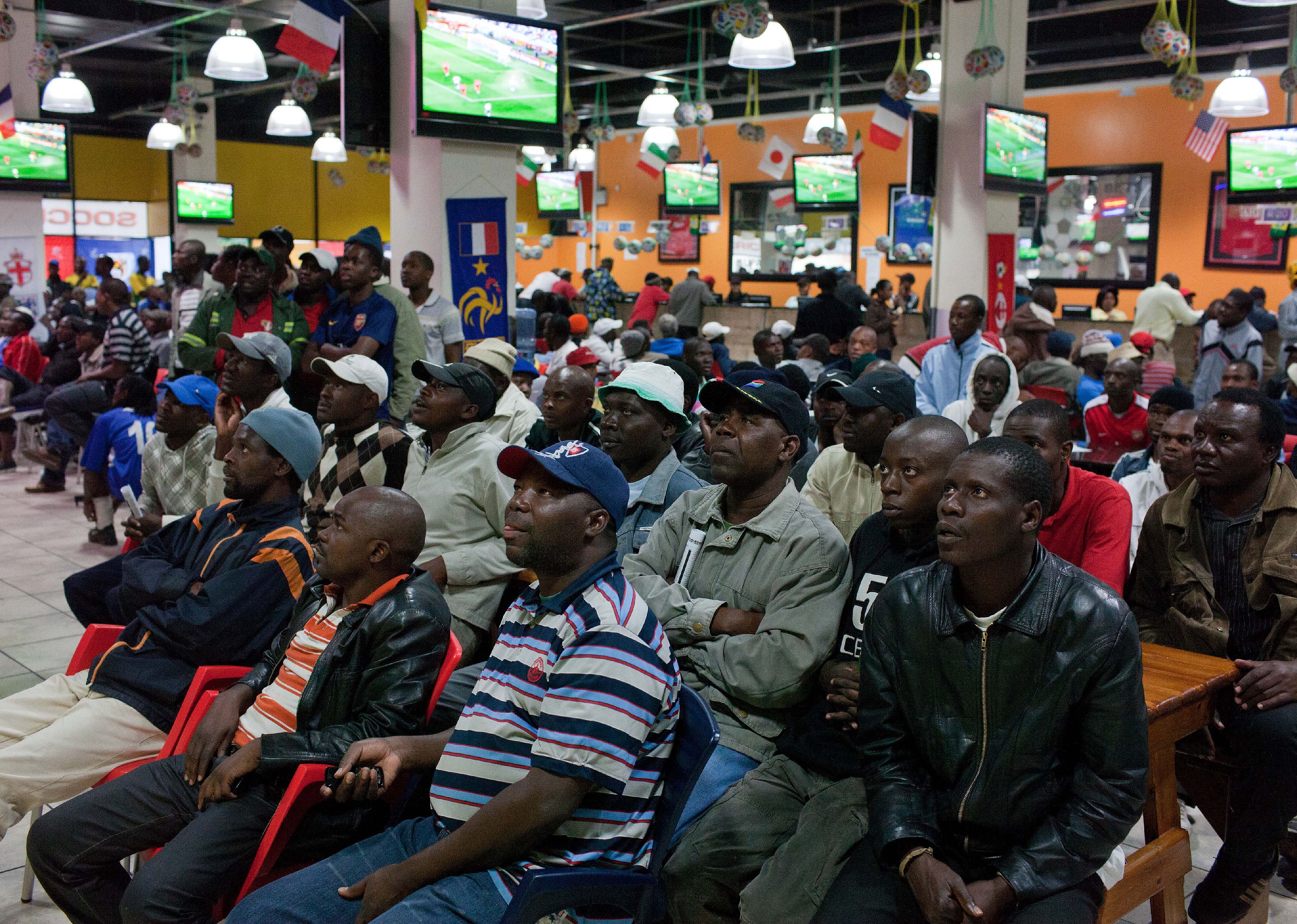 People who bet on the World Cup watch the game at a betting shop