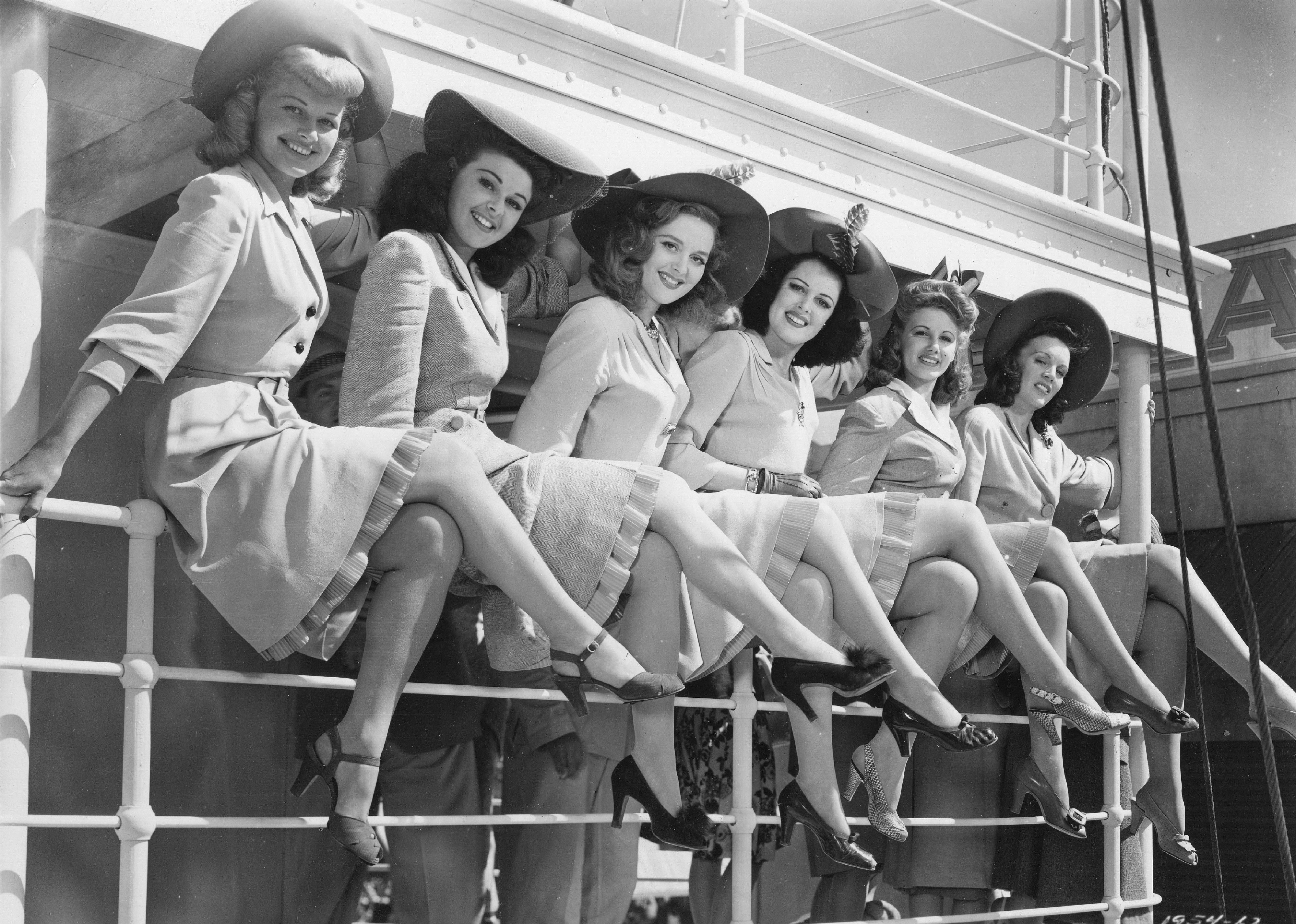 Group of women perched on an outdoor rail