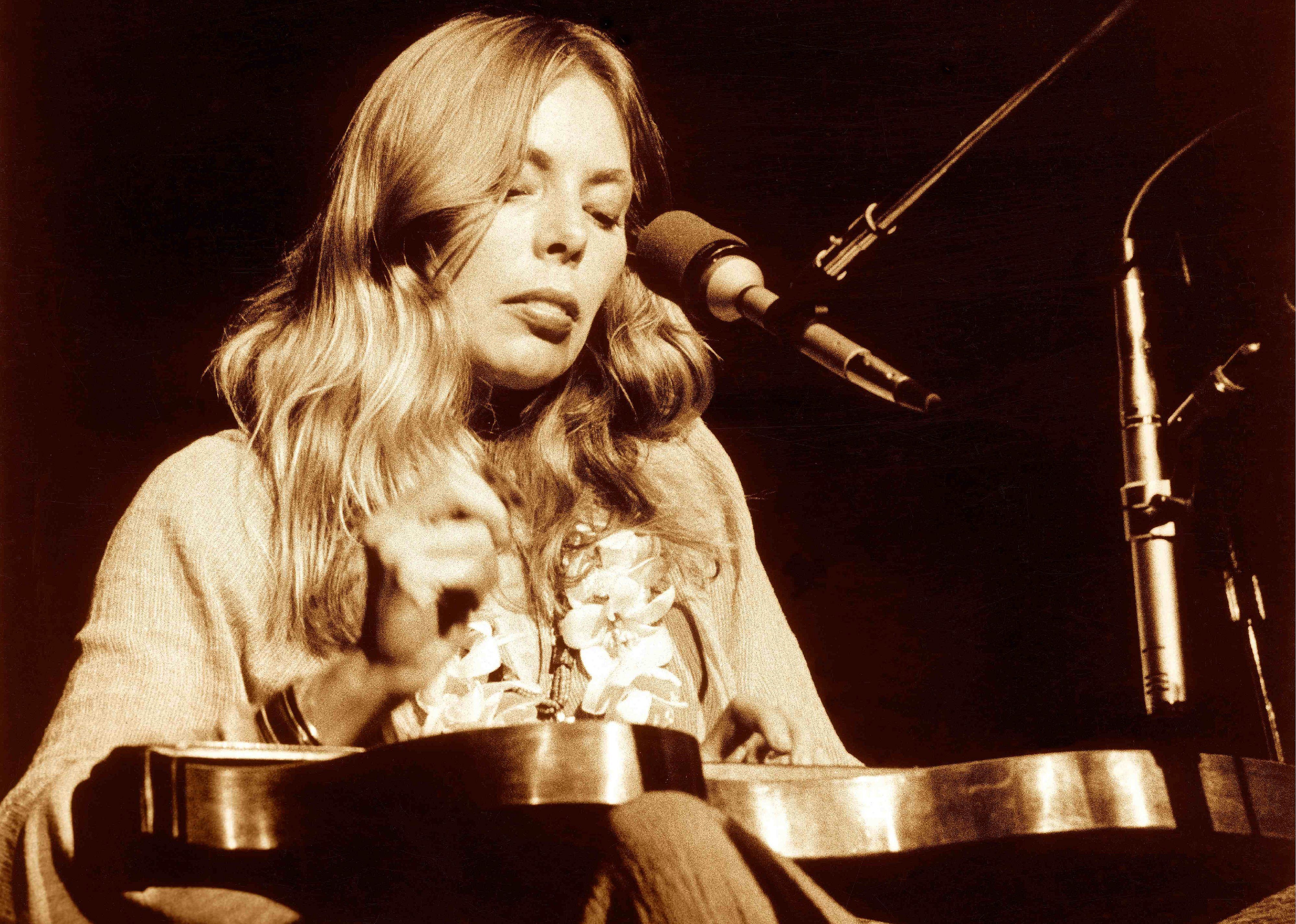 Joni Mitchell performing onstage.