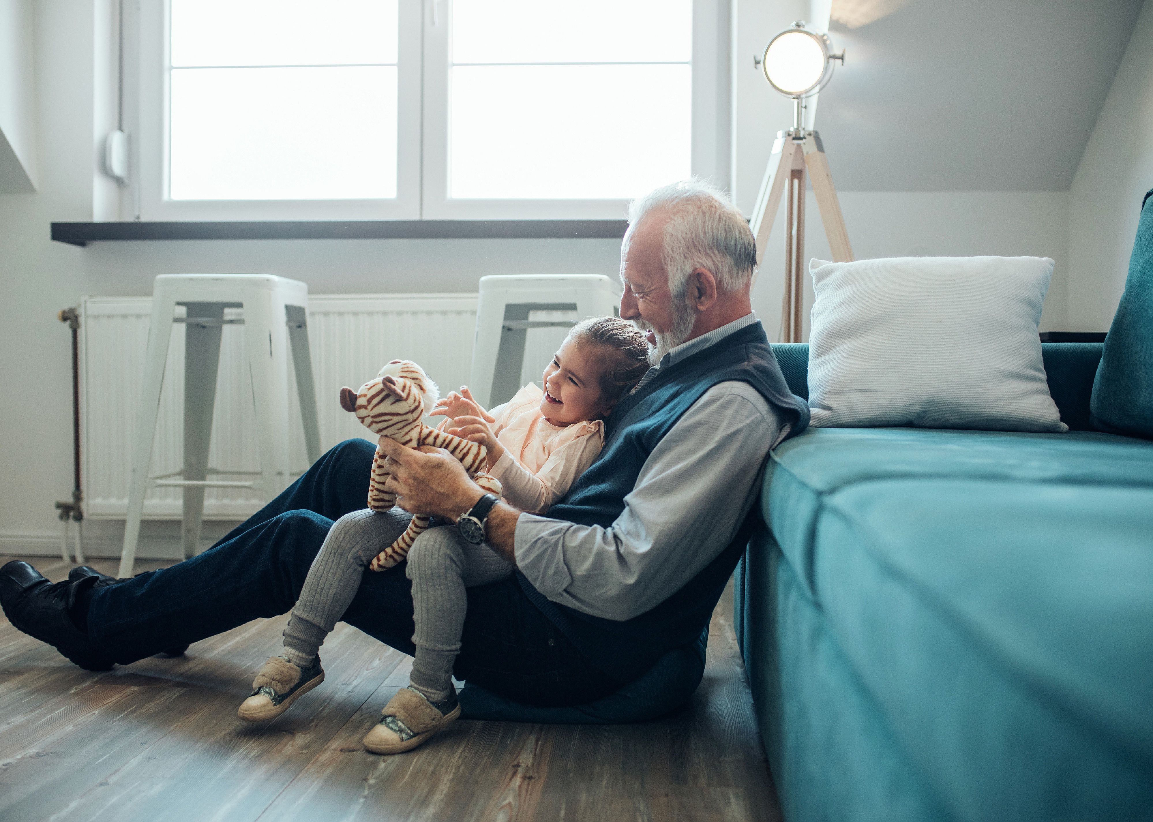 Elderly man holding his granddaughter.