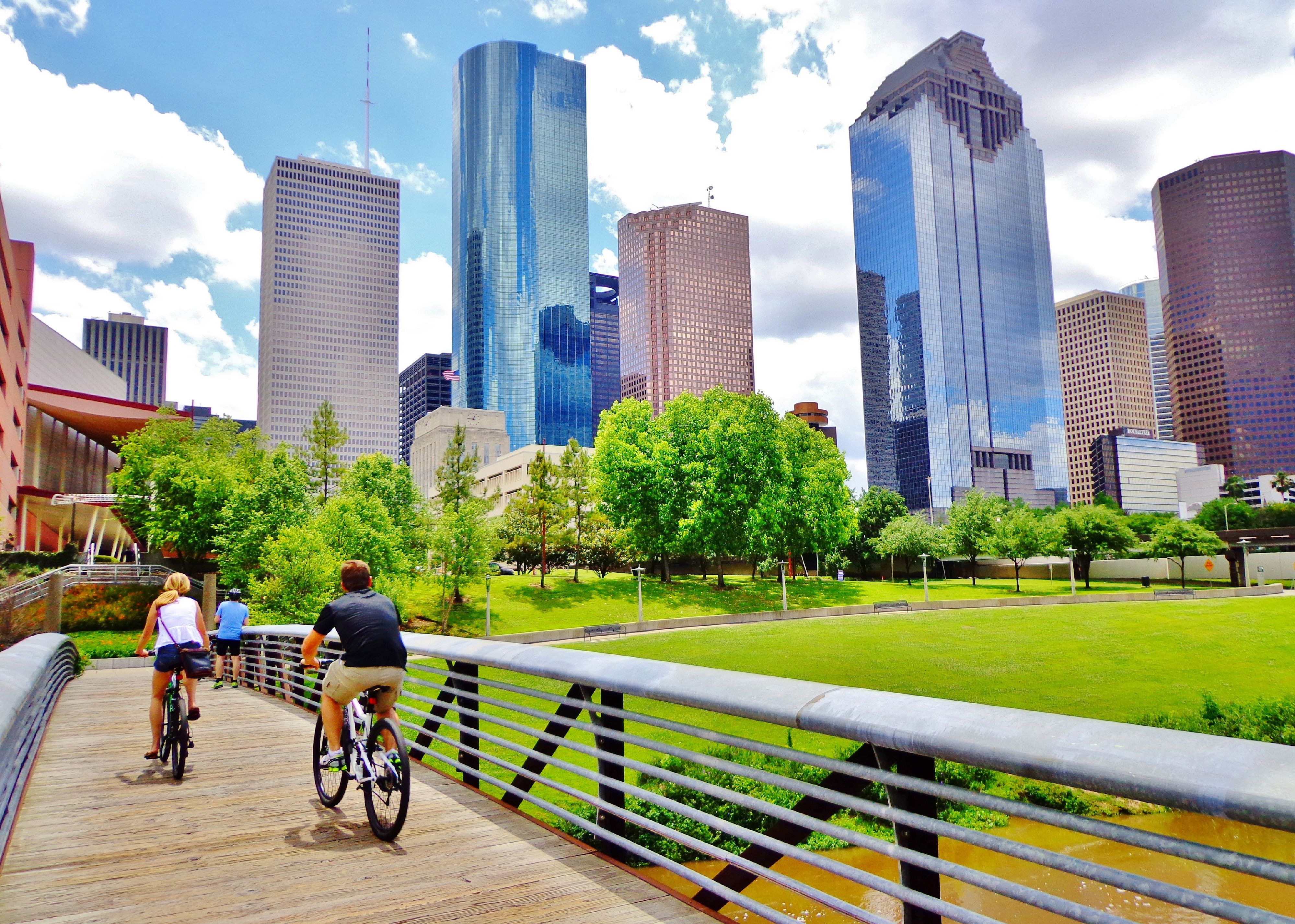 Bicyclists cross wooden bridge in Buffalo Bayou Park