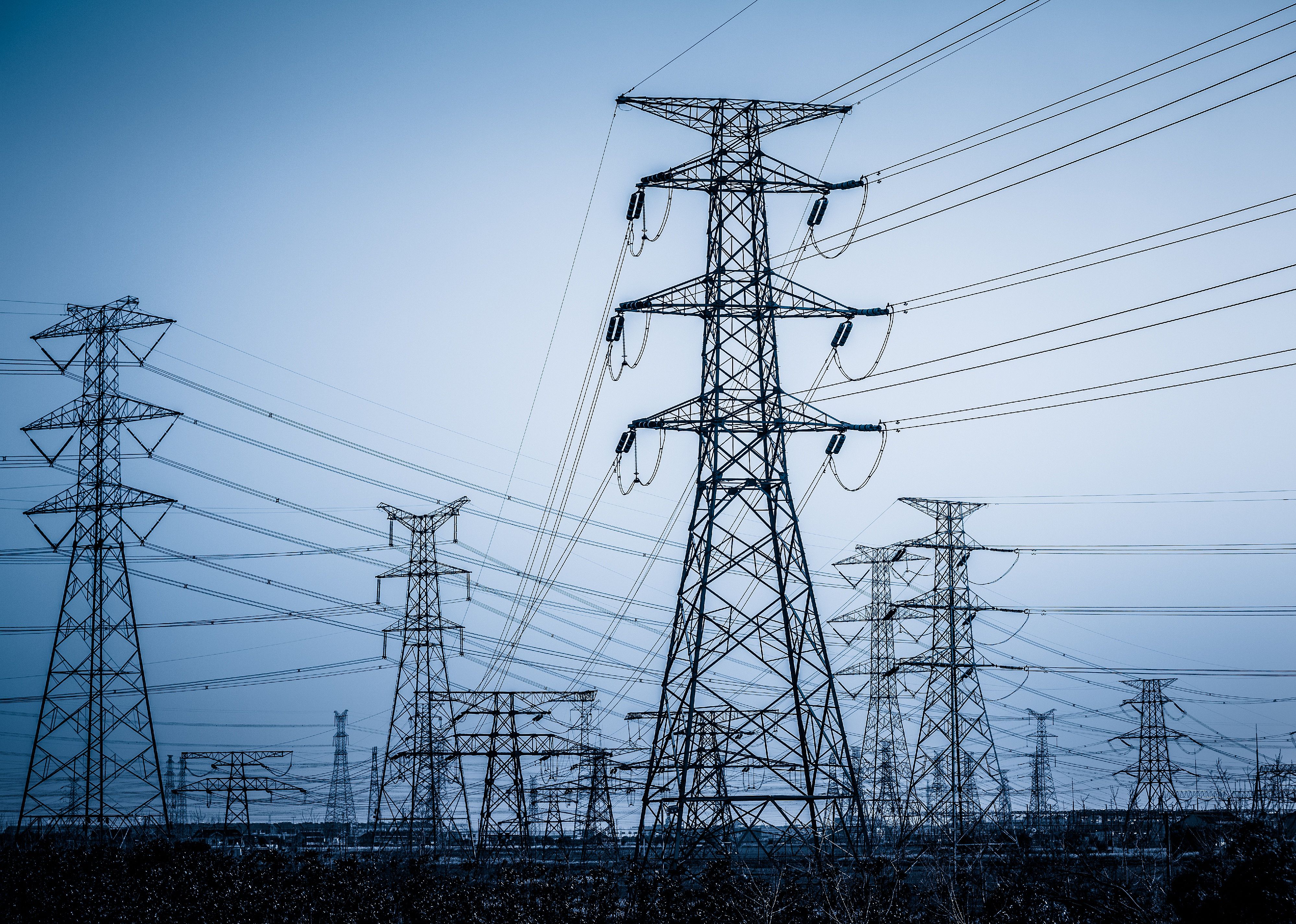 High voltage towers with sky background.