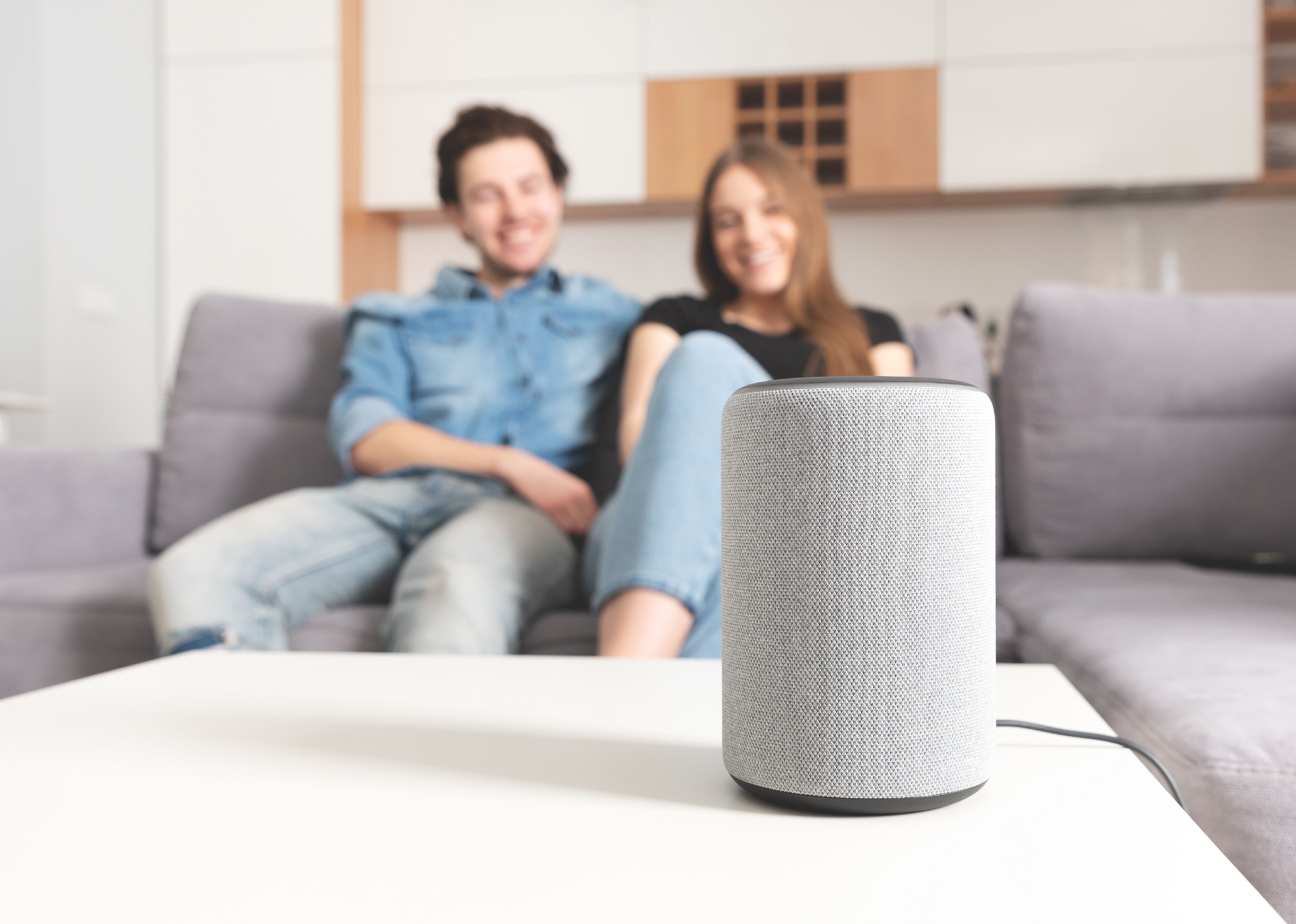 Couple talking command to smart speaker.