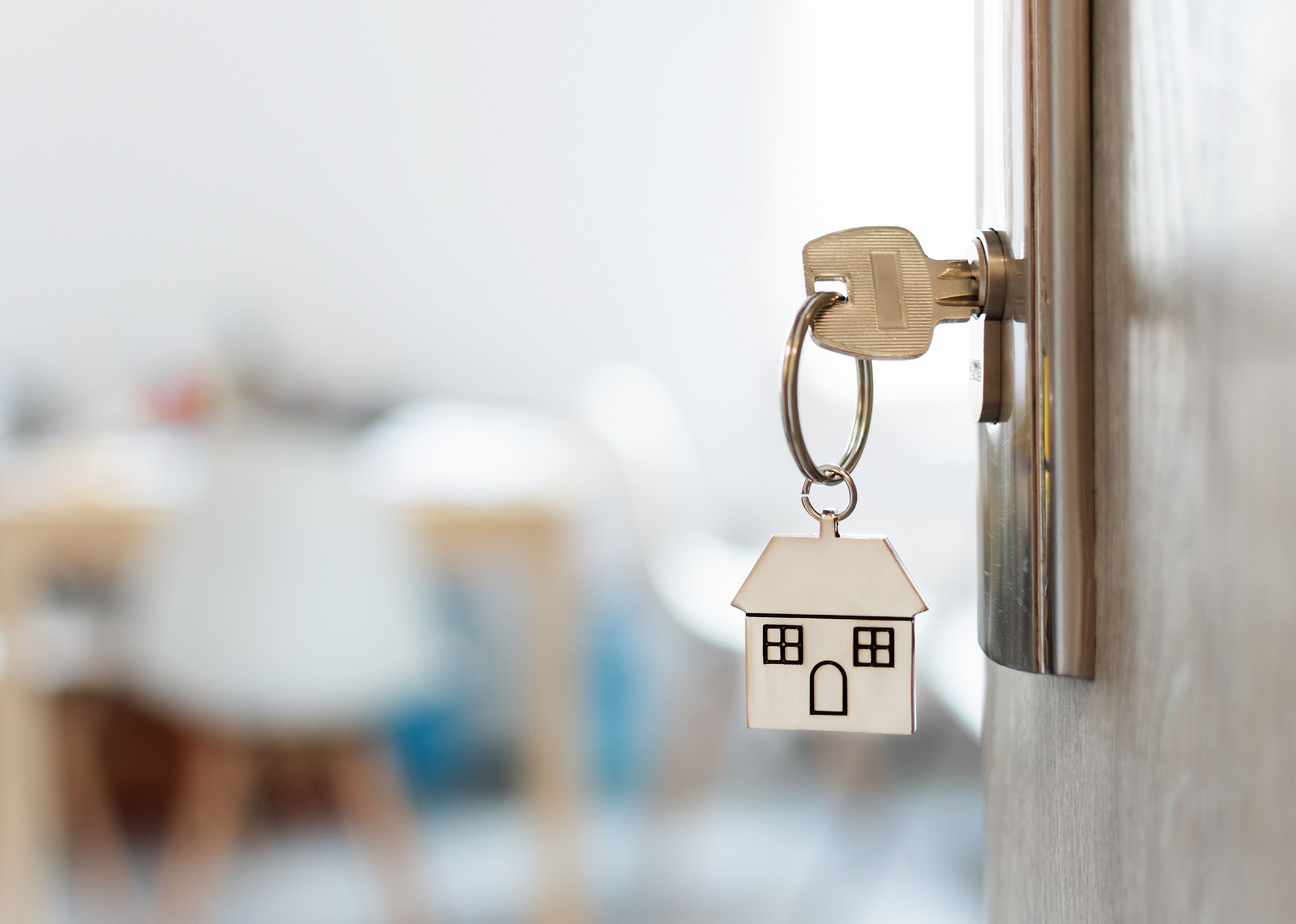 Key with keychain in a house shape in a door.