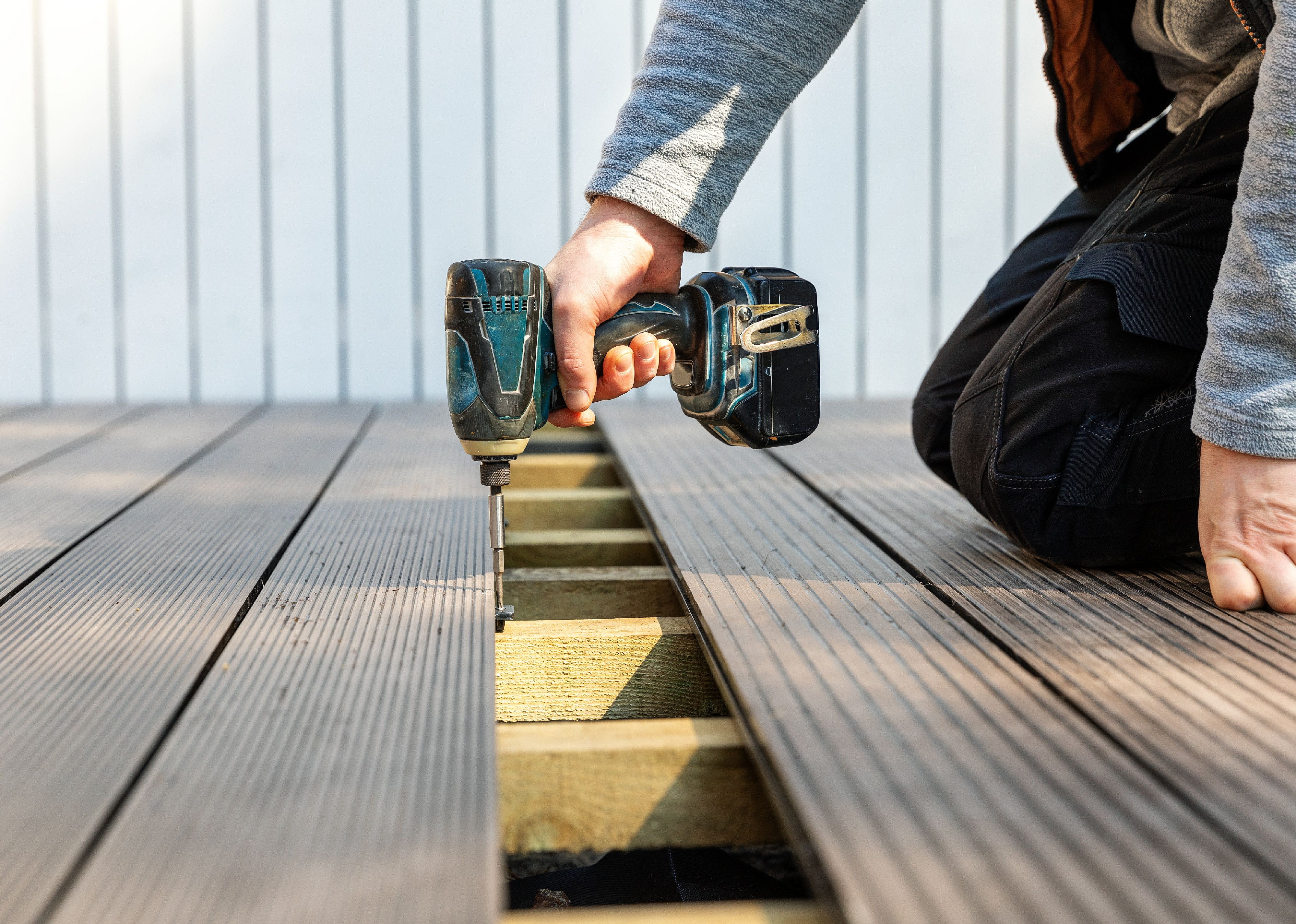Man installing wpc composite decking boards.