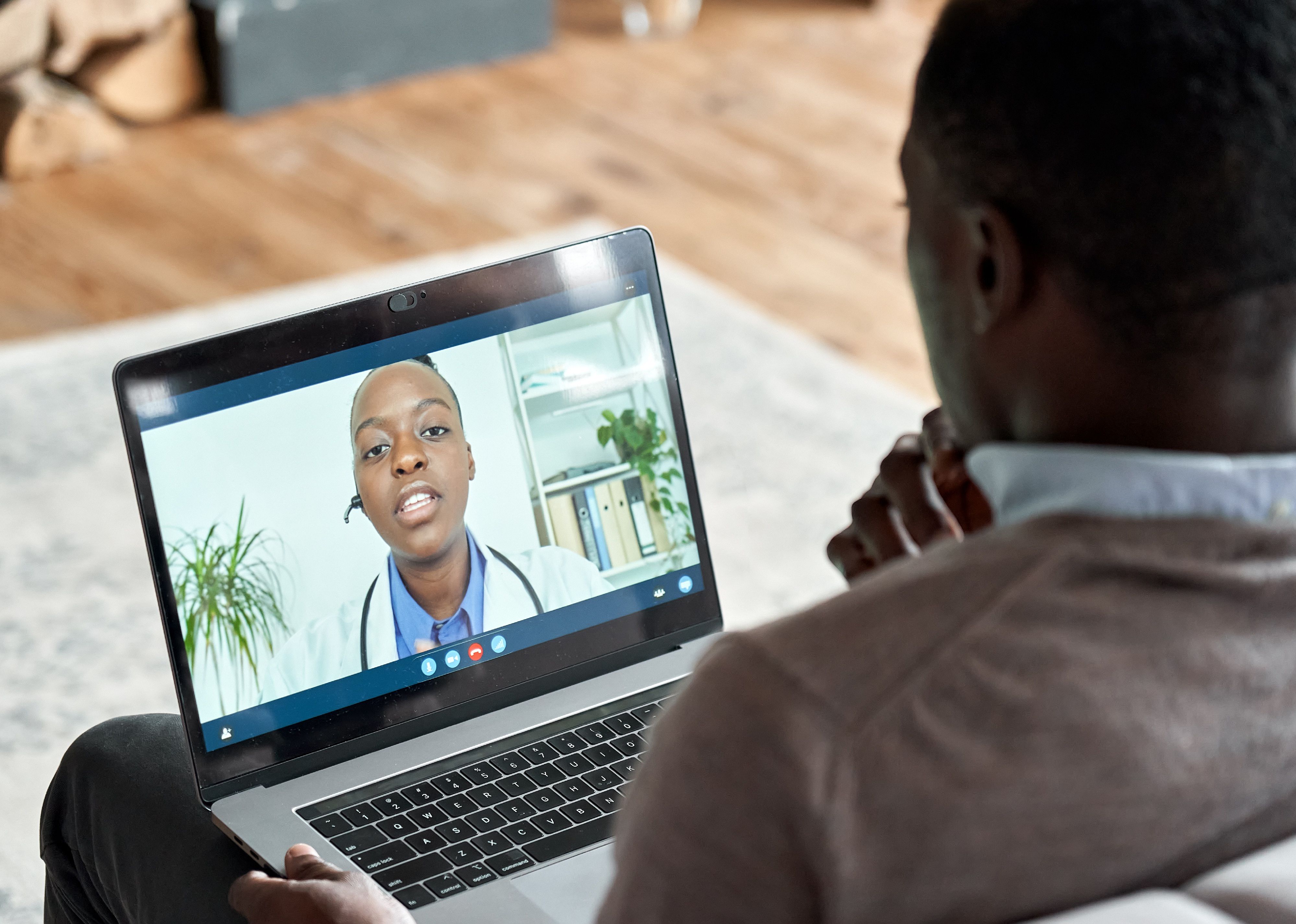 Male patient on conference video call with female doctor