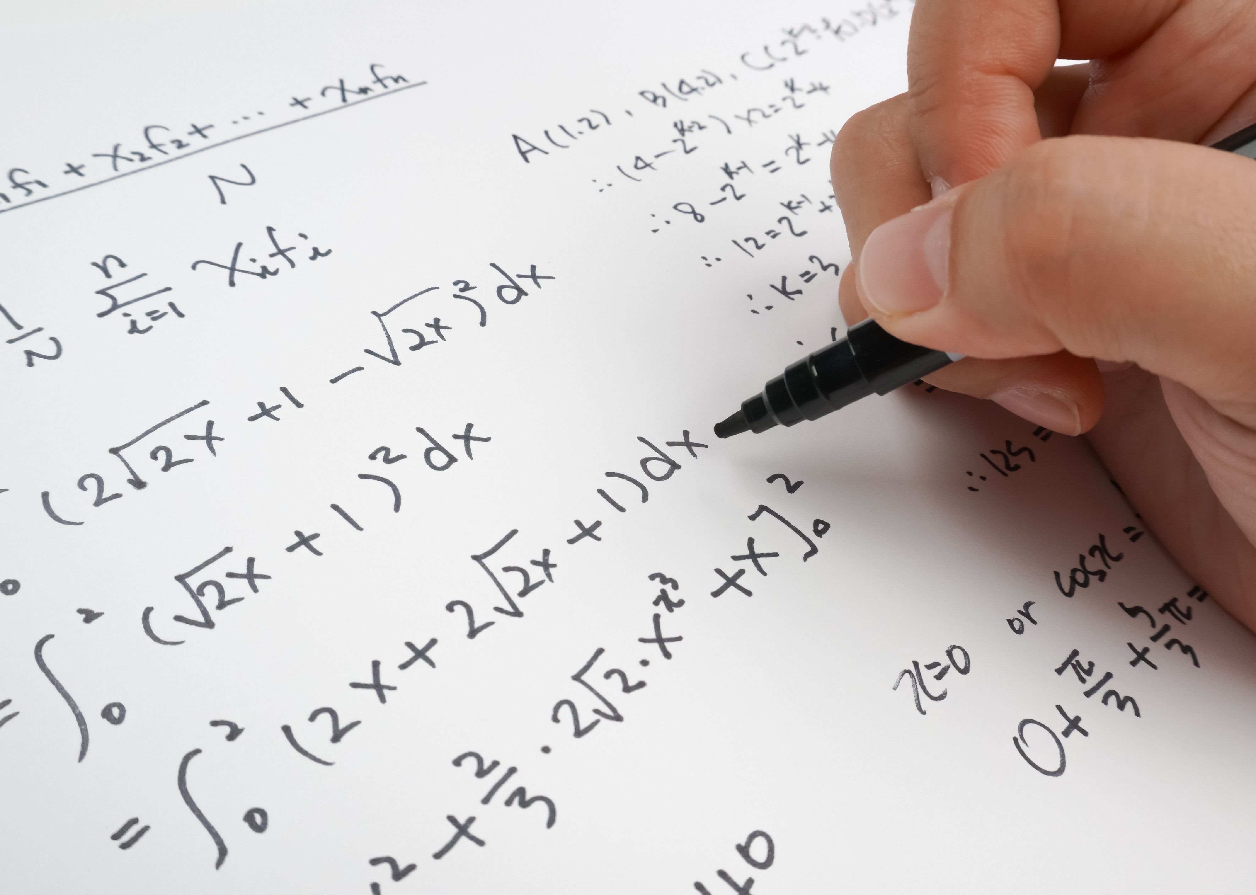 Close up of calculus work and hand holding pen
