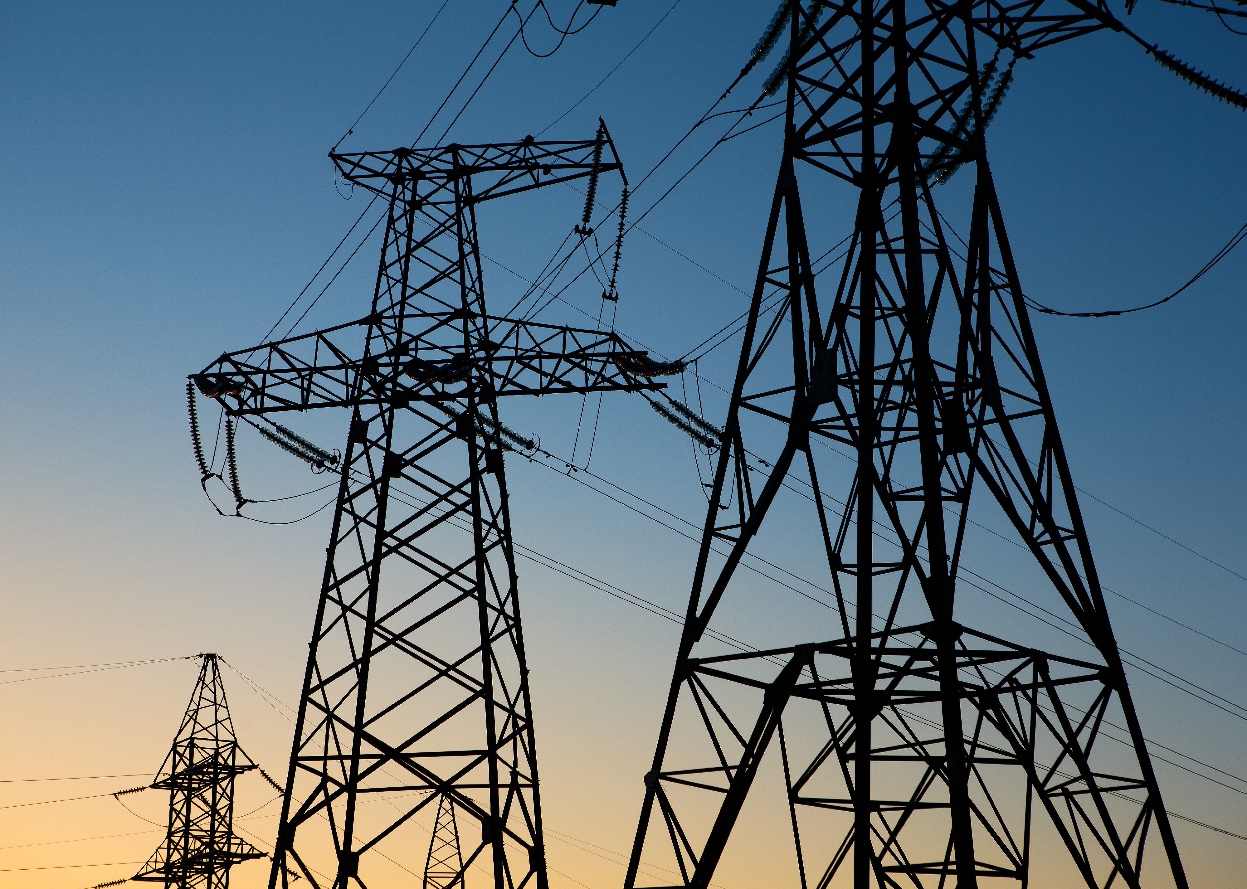 Silhouette of a high voltage electric tower at sunset.