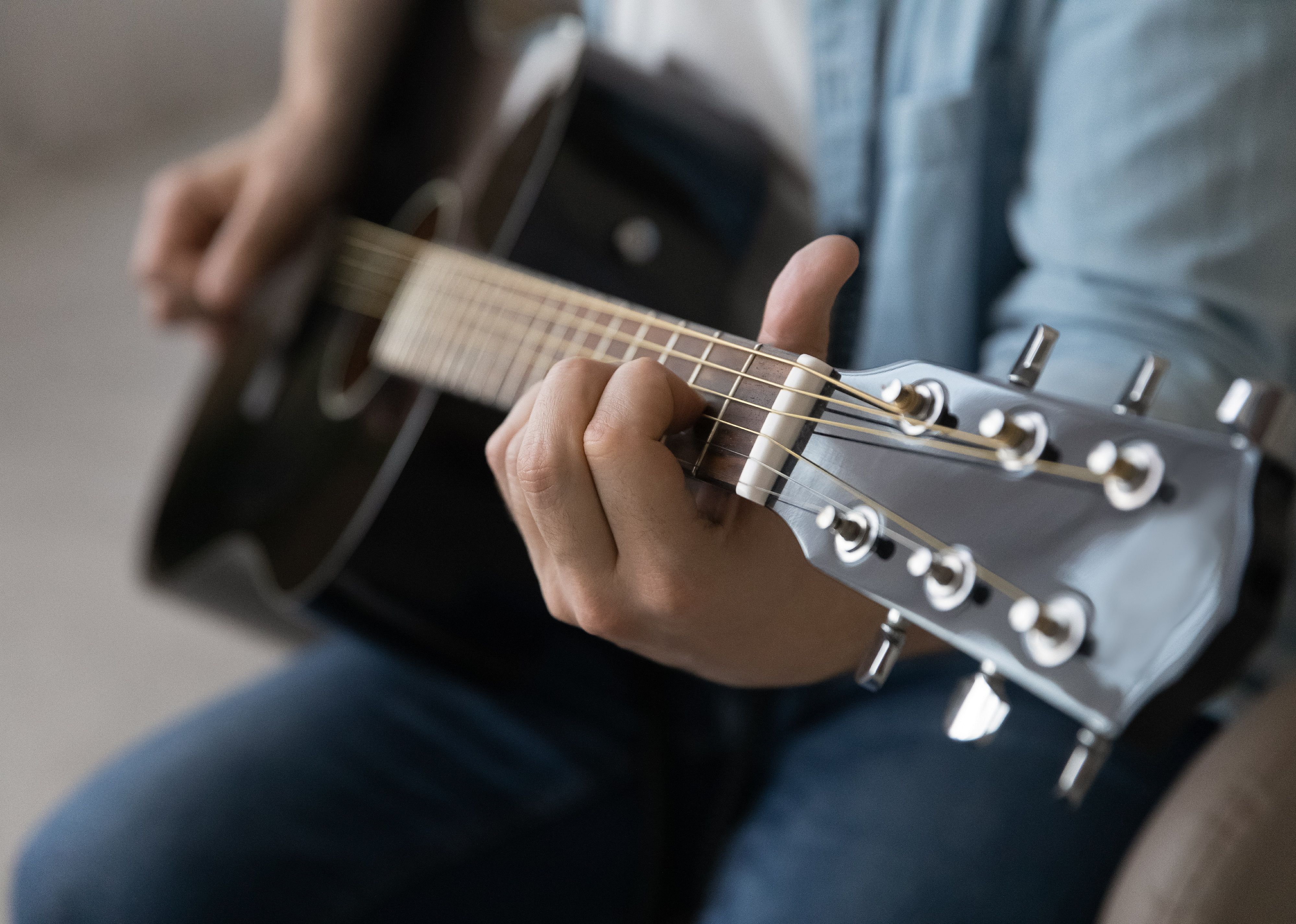 Close up man playing acoustic guitar