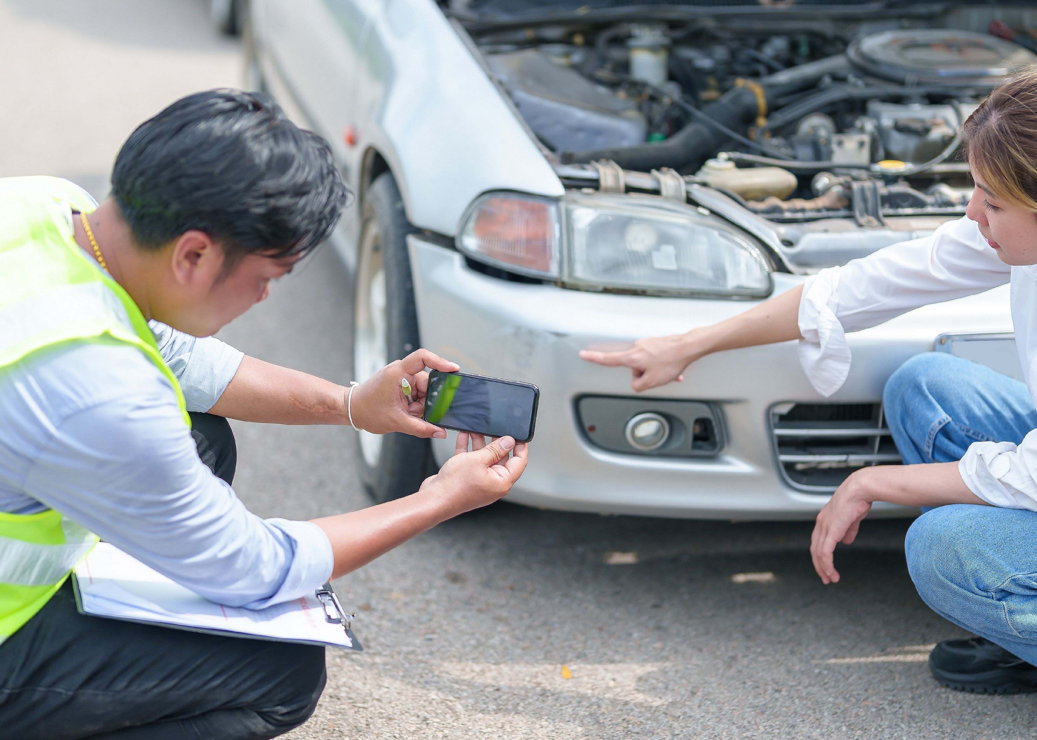 Insurance agent takes pictures of crashed car on his smartphone