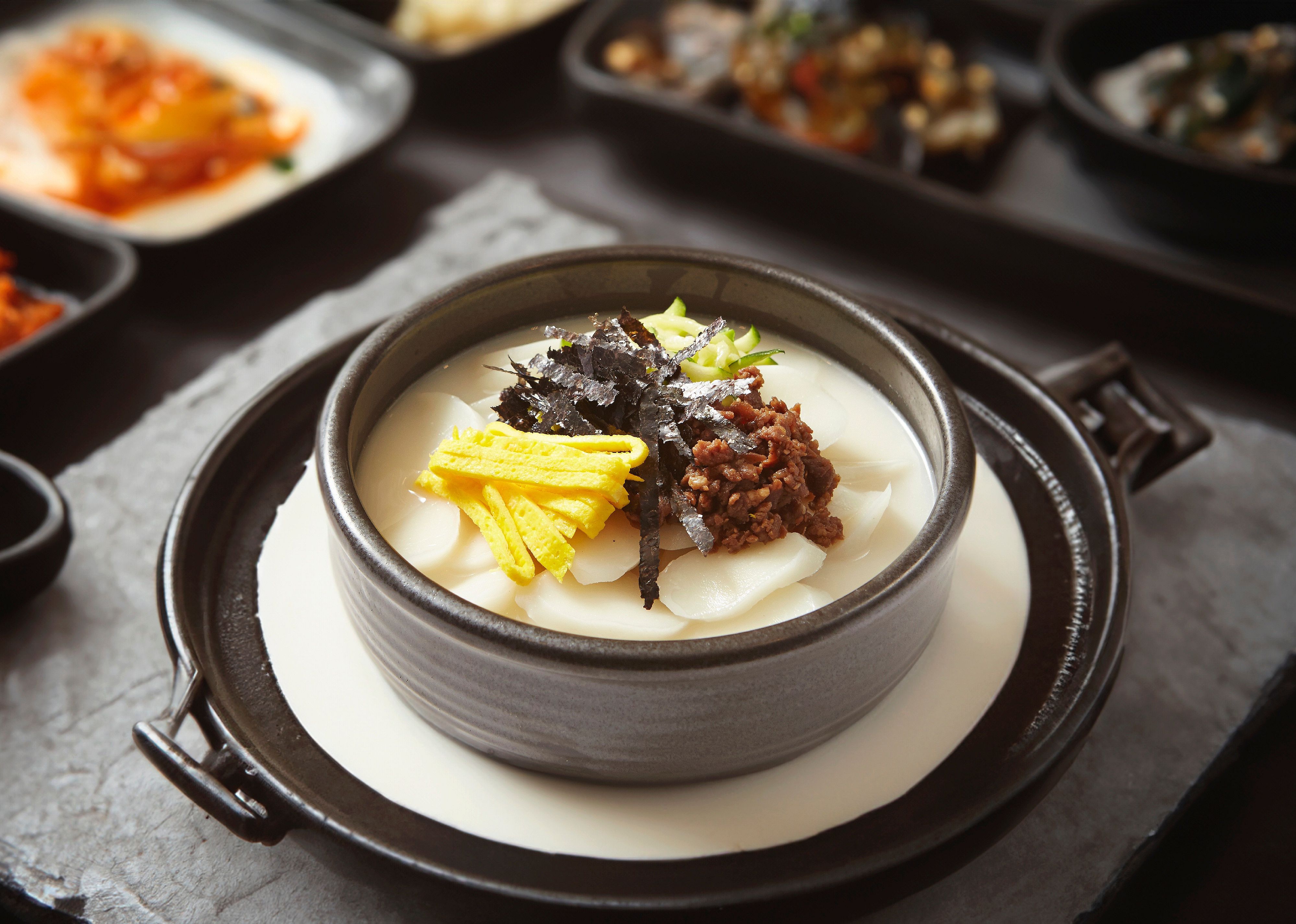 Tteokguk prepared with slices of rice cake, beef, eggs.