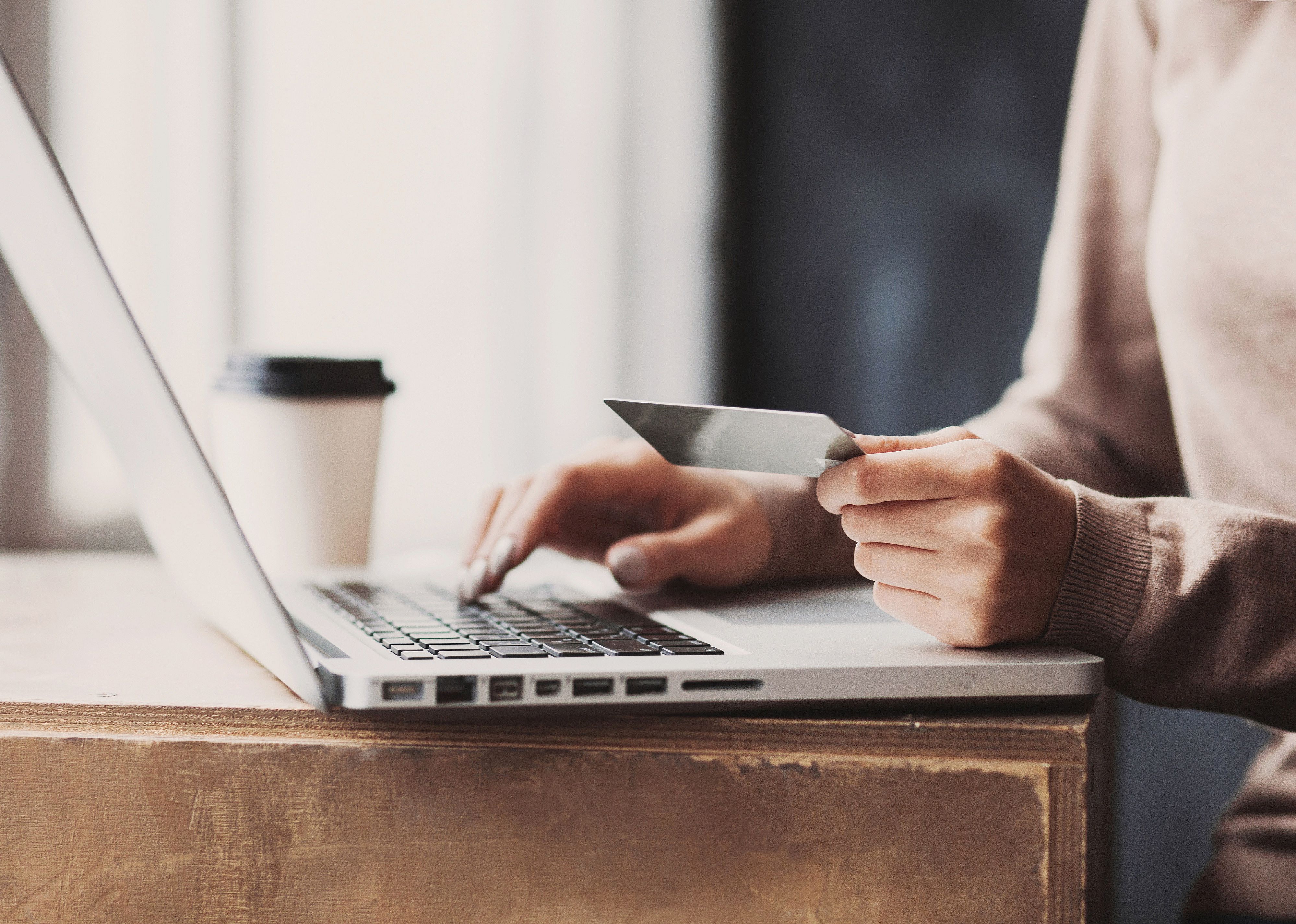 Woman hand holding credit card and using laptop.