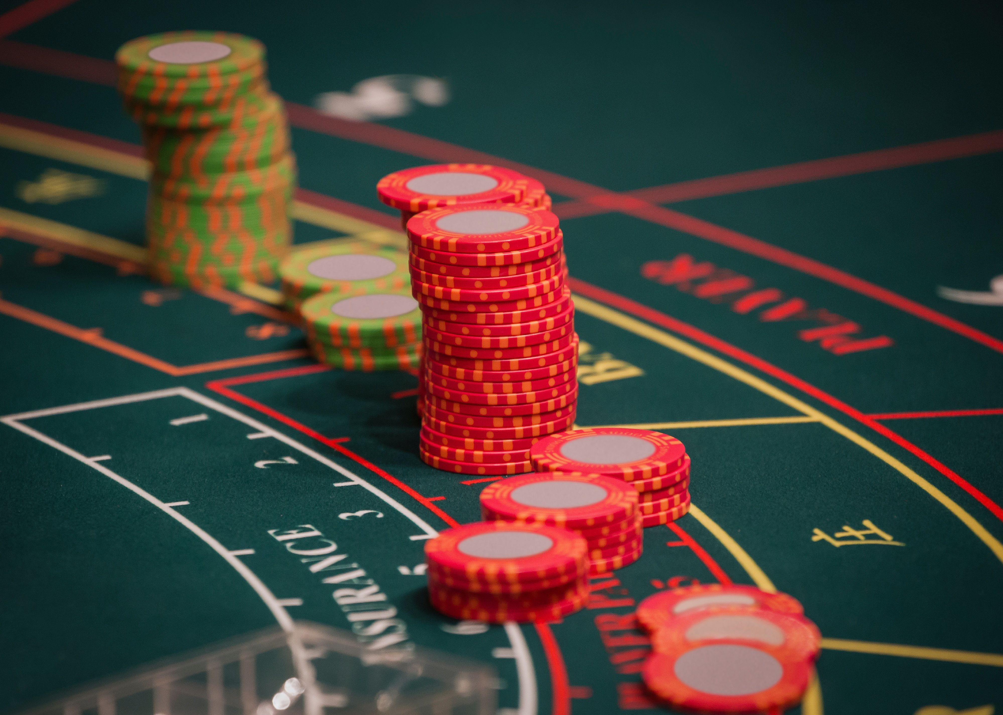 Red and green Baccarat chips on Baccarat table.