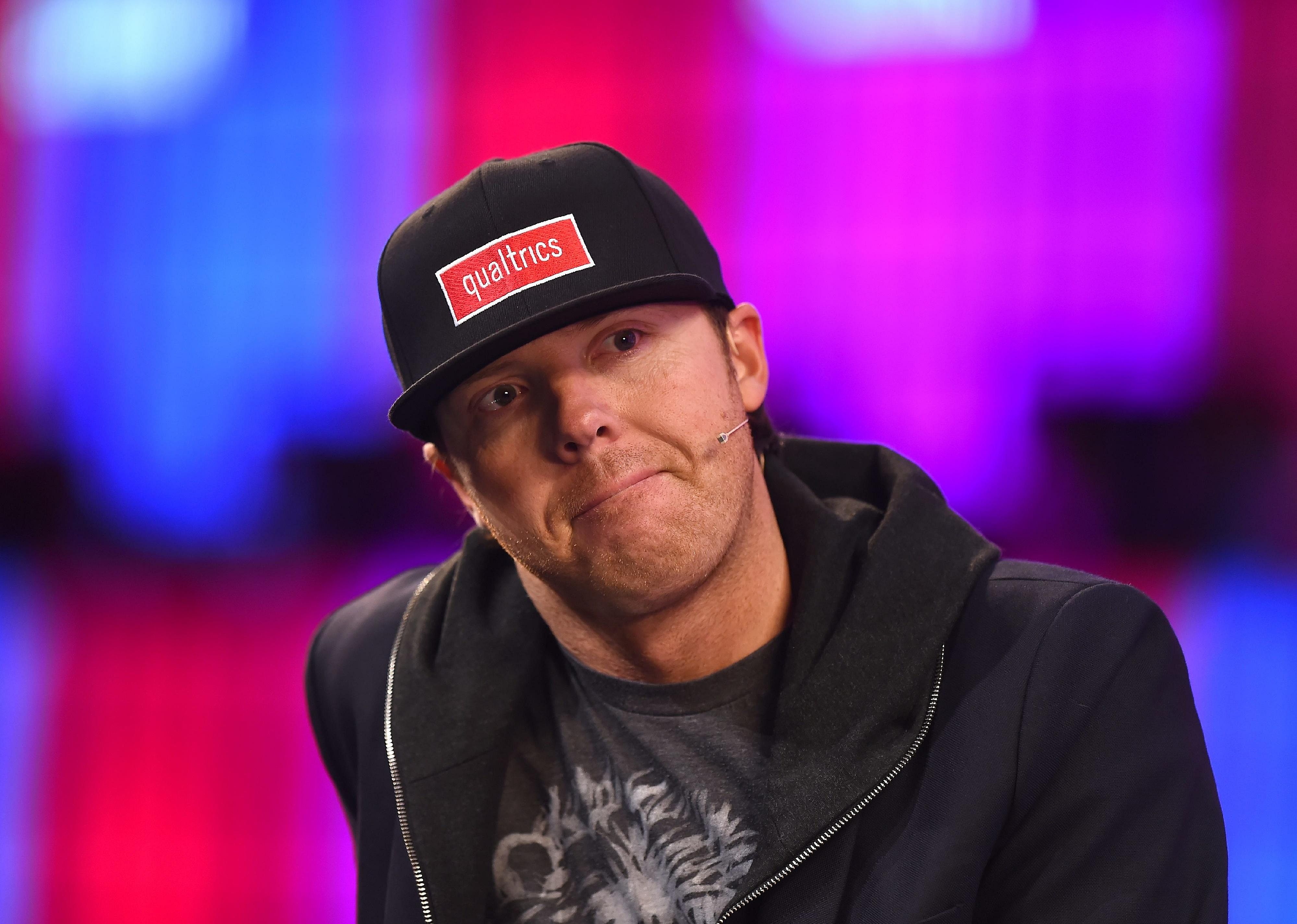 Ryan Smith onstage wearing a black hat and hoodie.