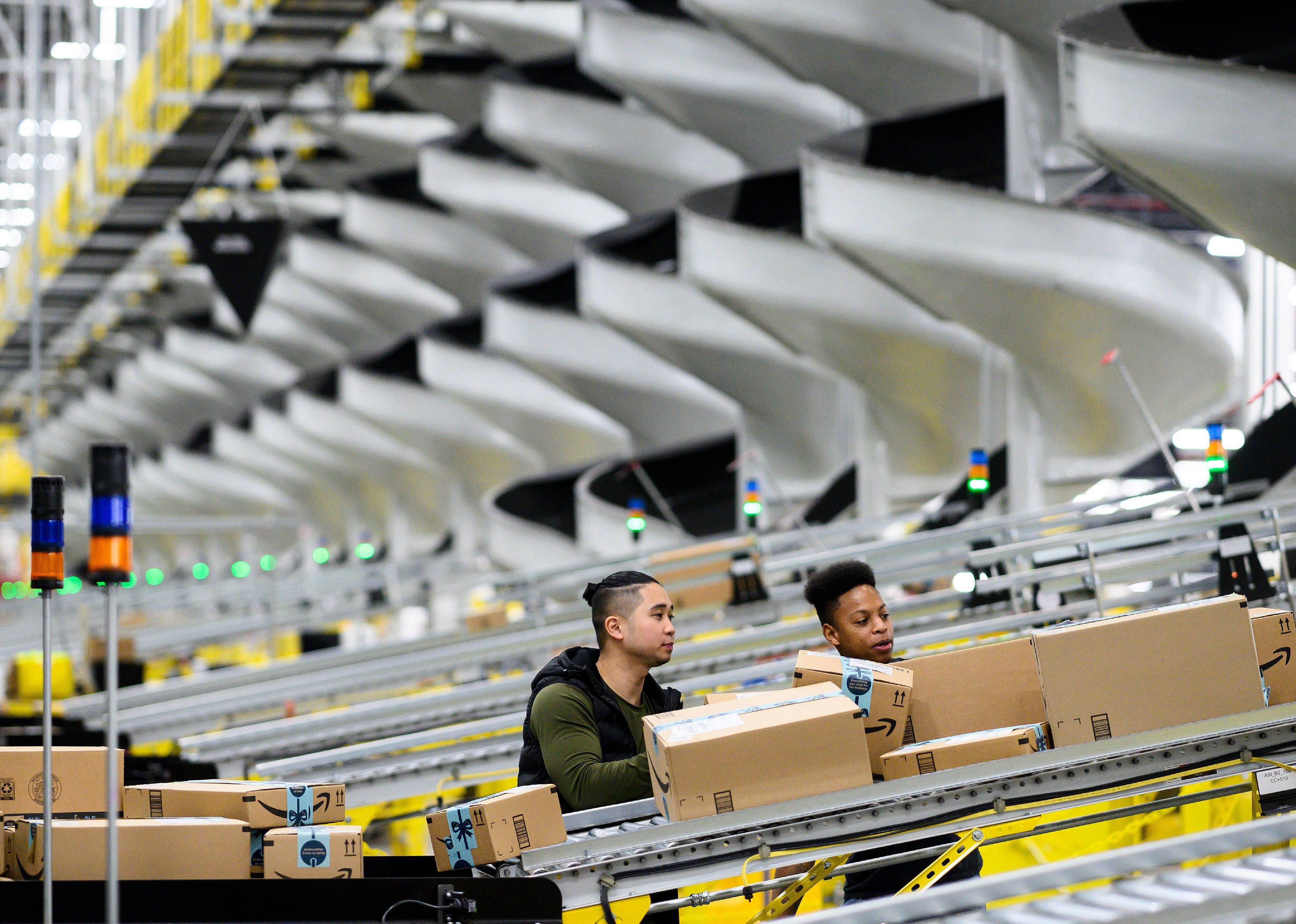 Employees moving boxes inside an Amazon fulfillment center.
