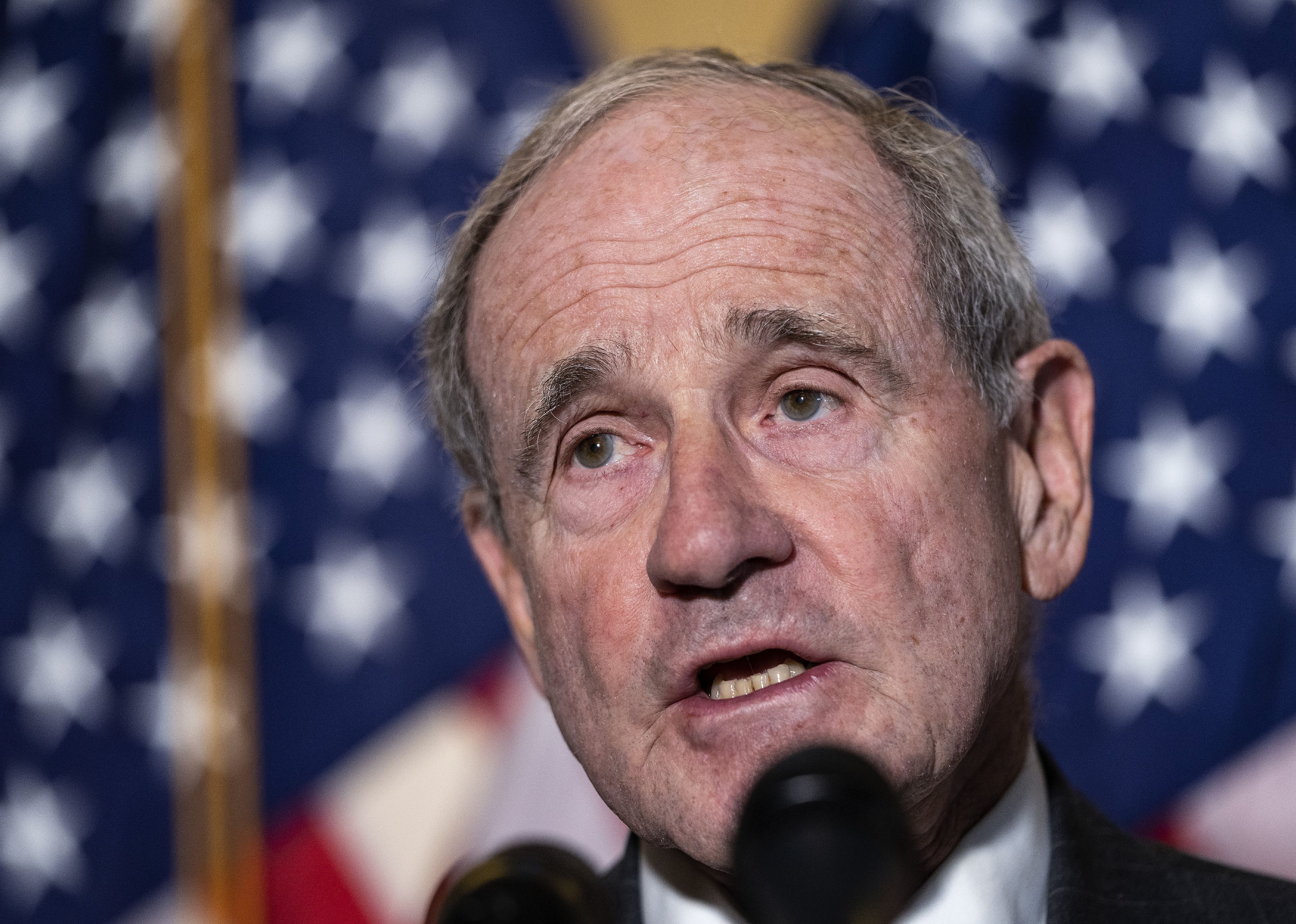 James Risch in front of an American flag.