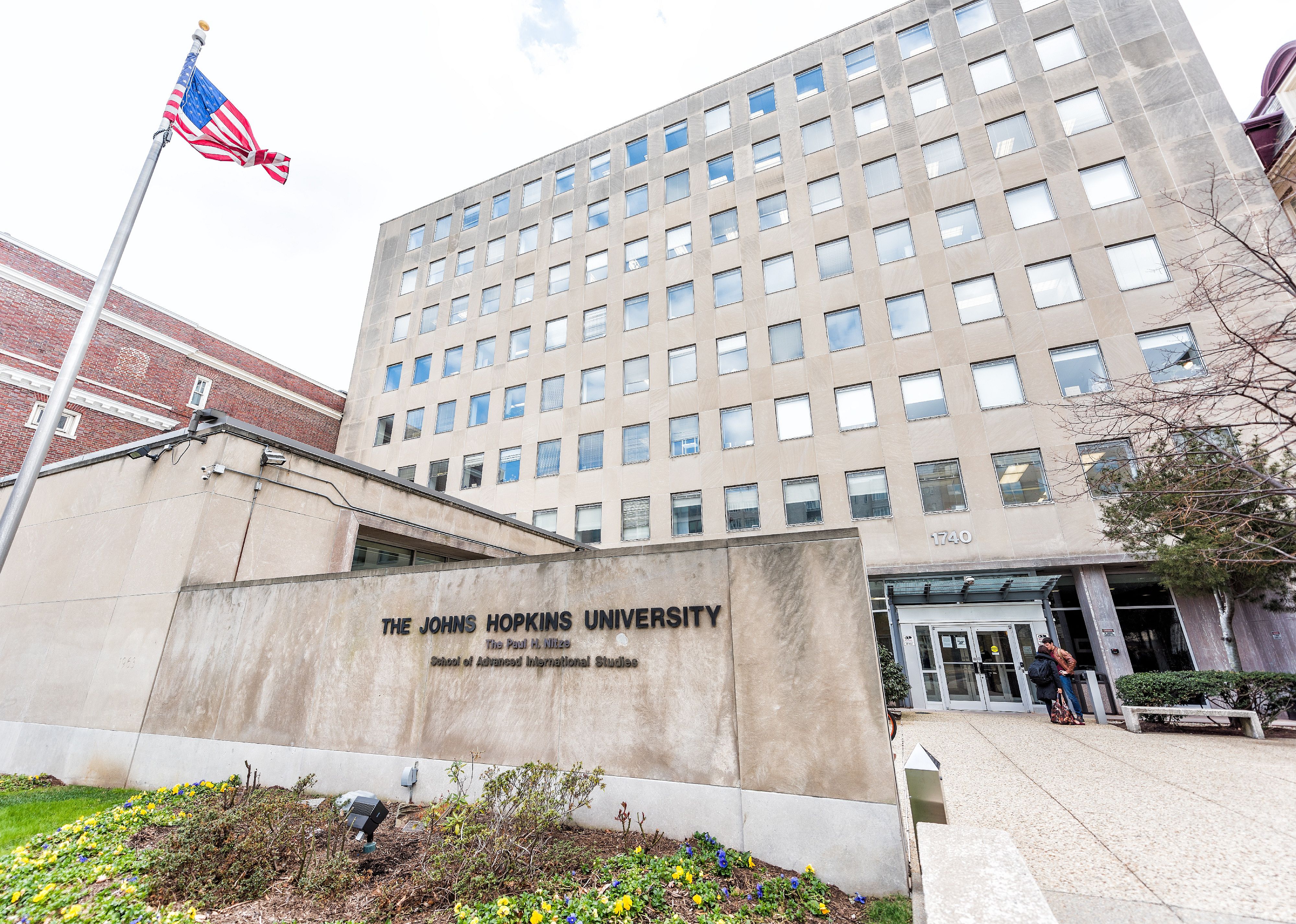Johns Hopkins University sign, entrance with American flag.