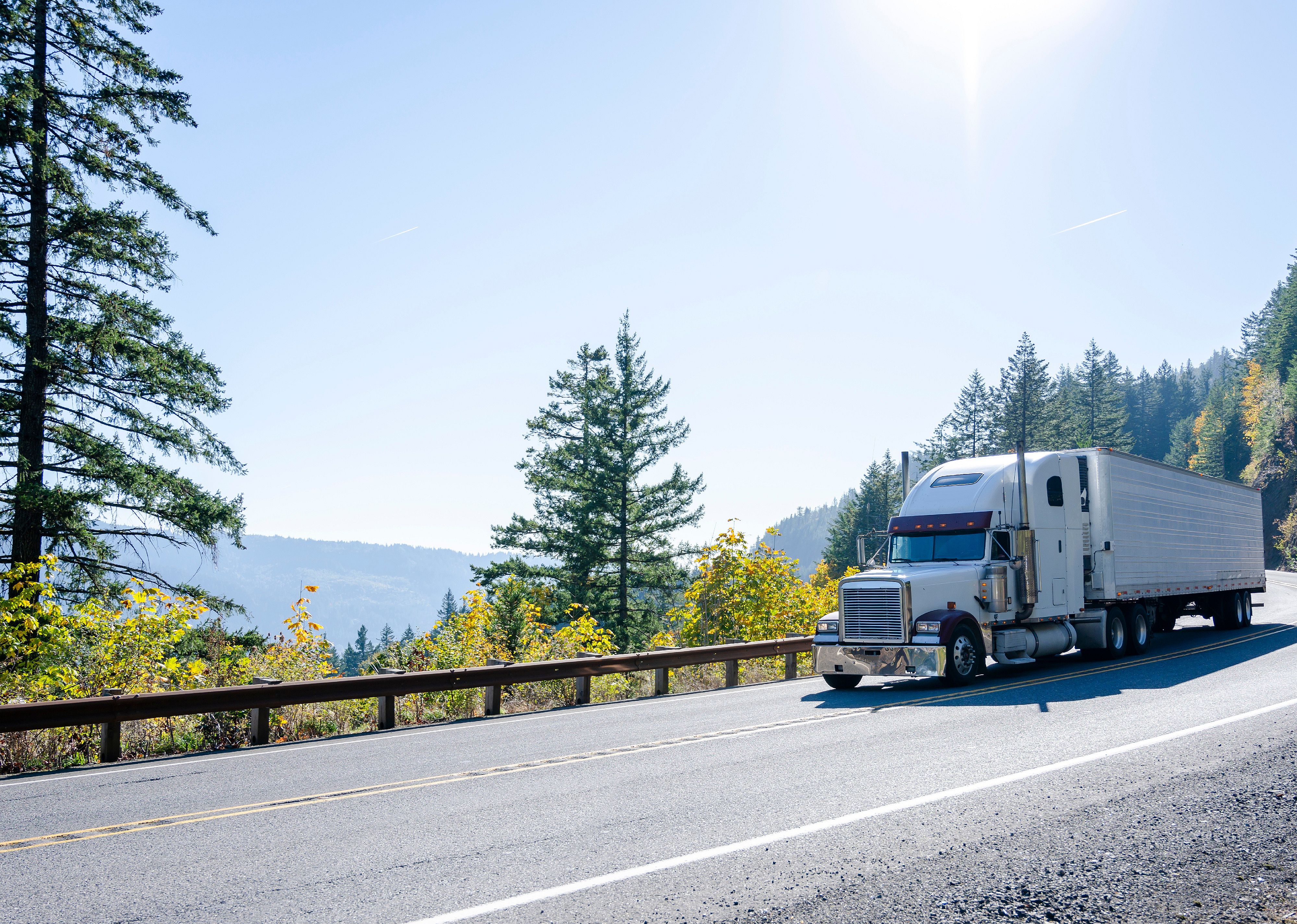 White classic semi truck transporting cargo in refrigerated trailer on a road in Washington